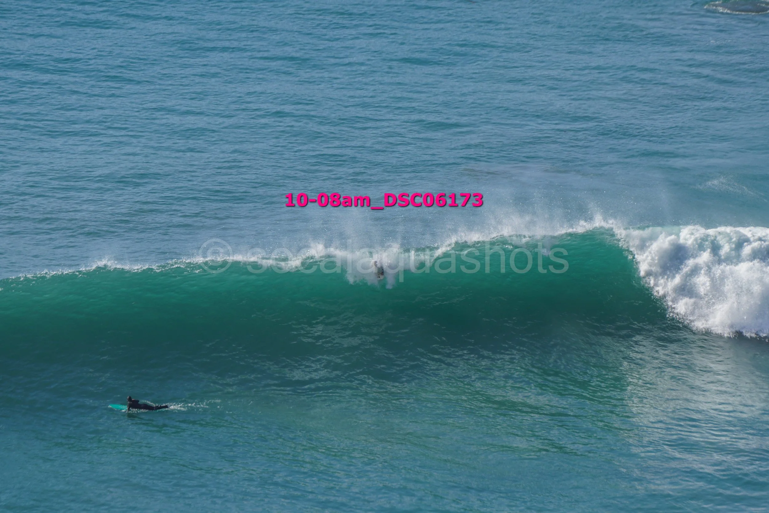 A surfer riding a large wave in the ocean during daytime.