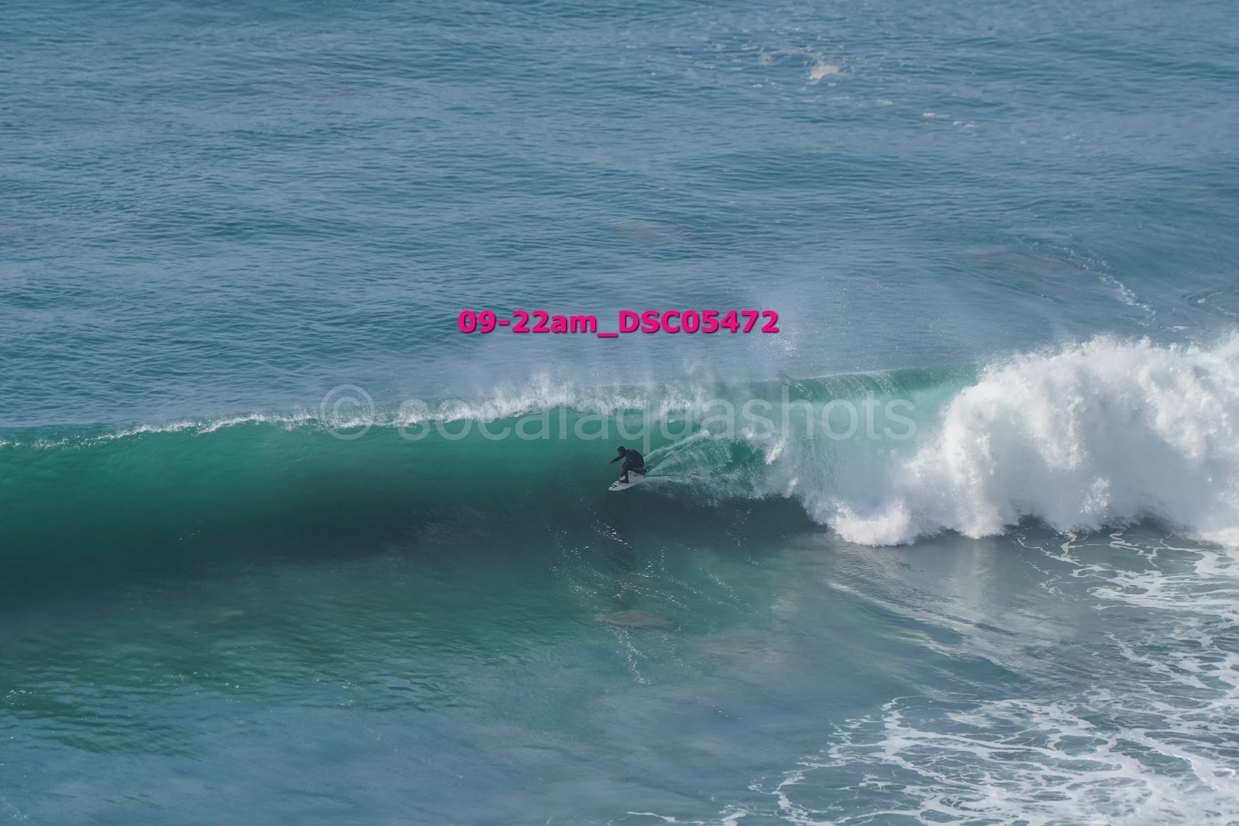 A surfer riding a wave in the ocean with a distant horizon