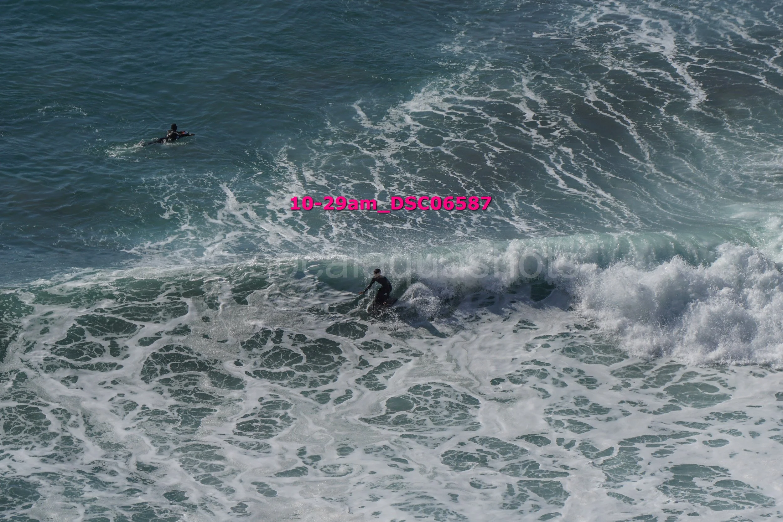 Two surfers riding waves in the ocean.