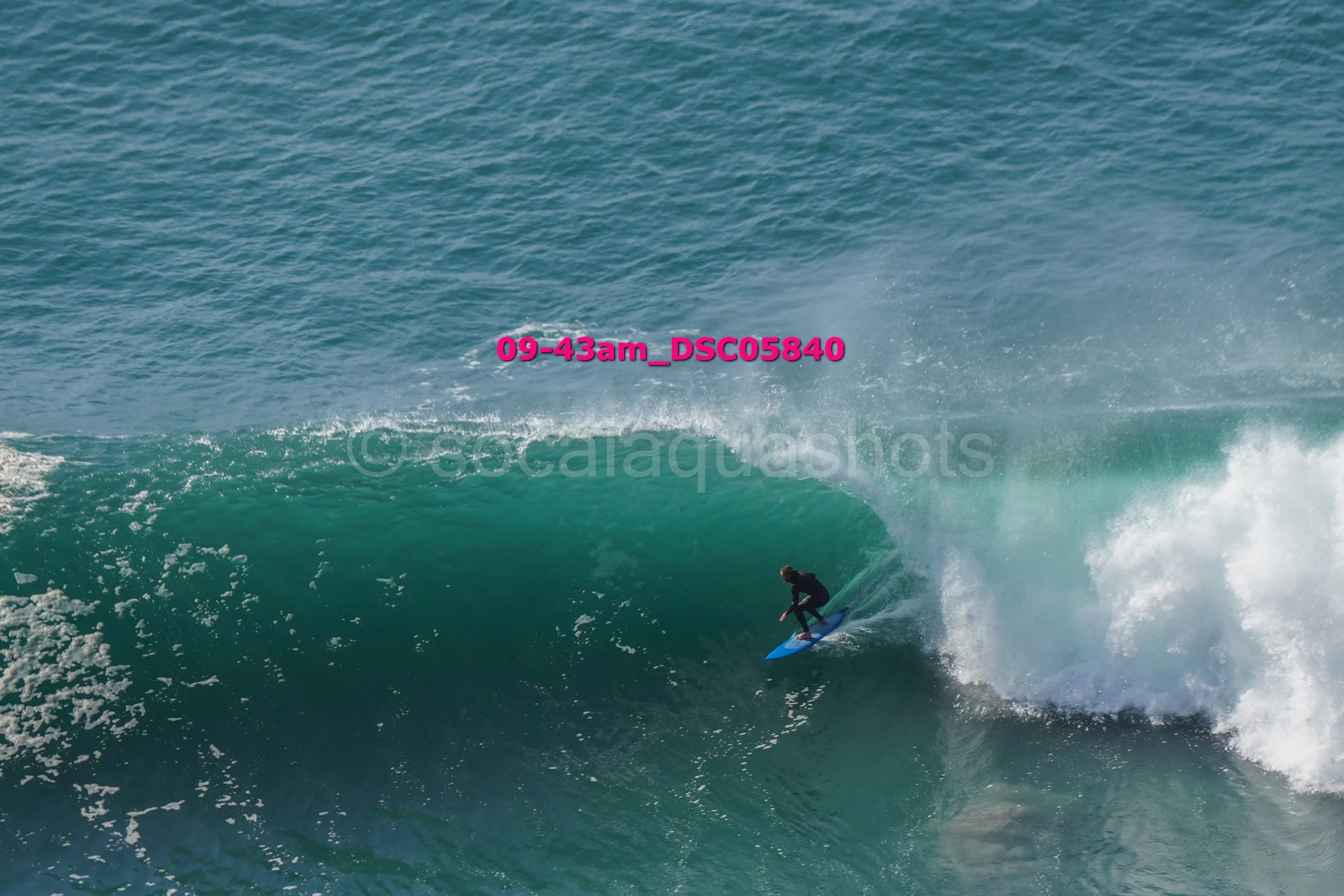 A surfer riding inside a large ocean wave.