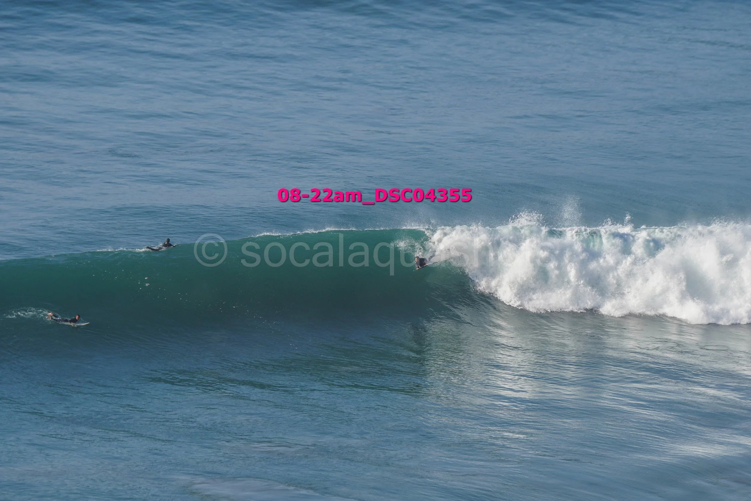 Surfers riding a large wave in the ocean.