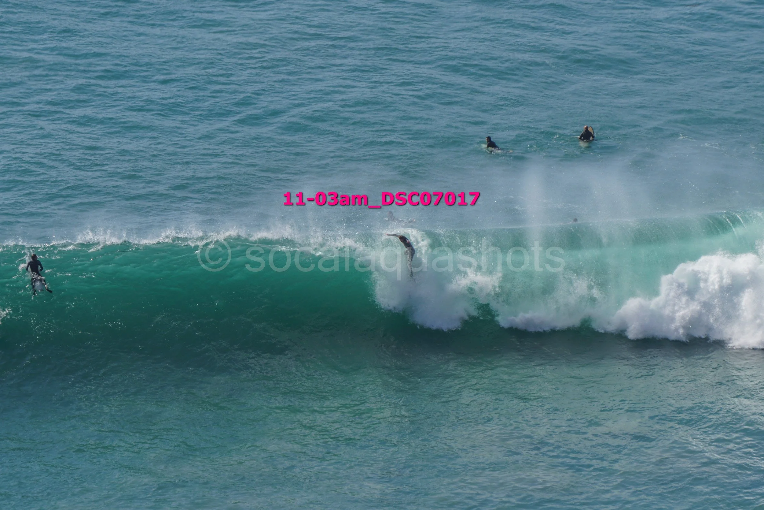Surfers riding and waiting for waves in the ocean.