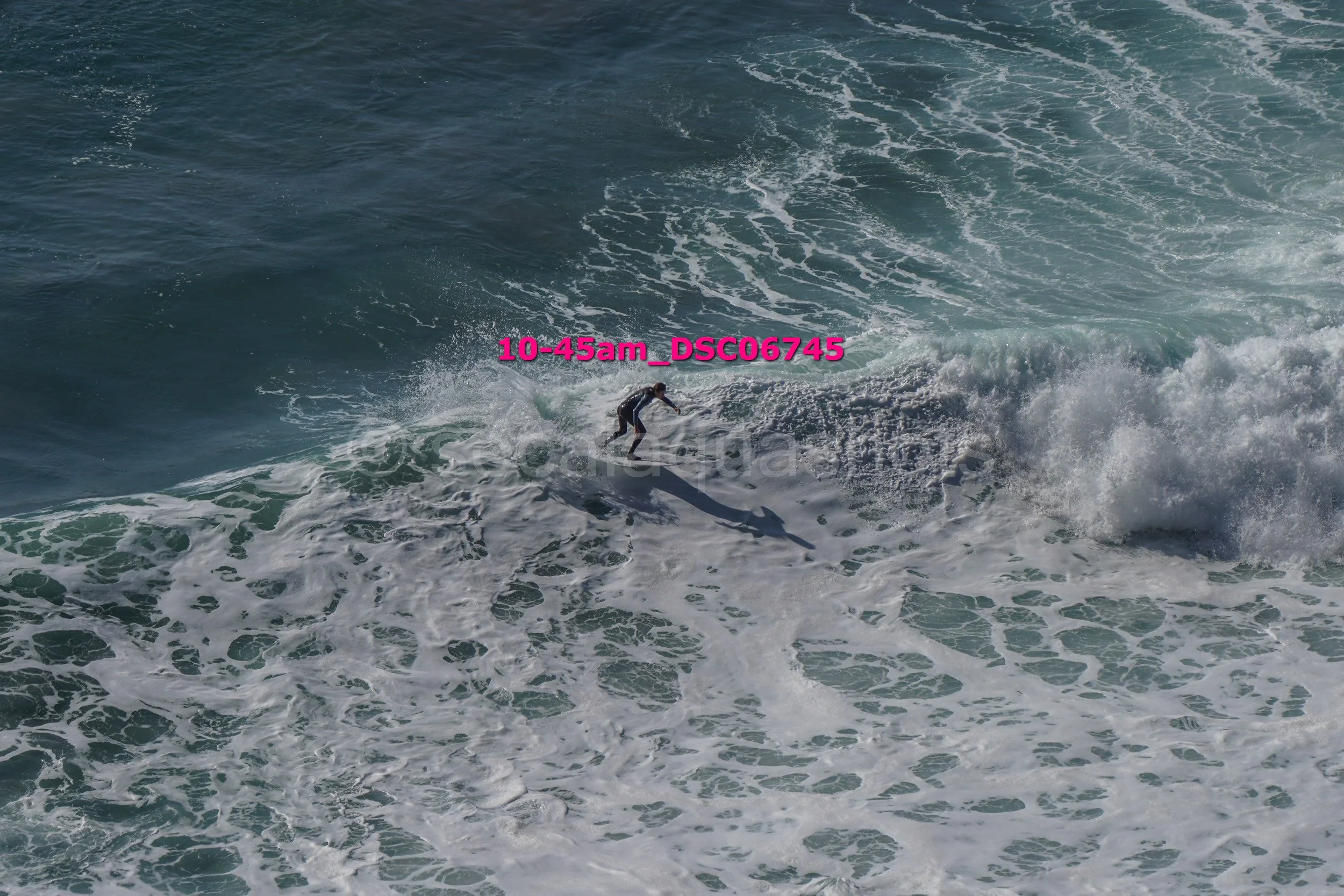 A person surfing on a wave in the ocean during daytime.