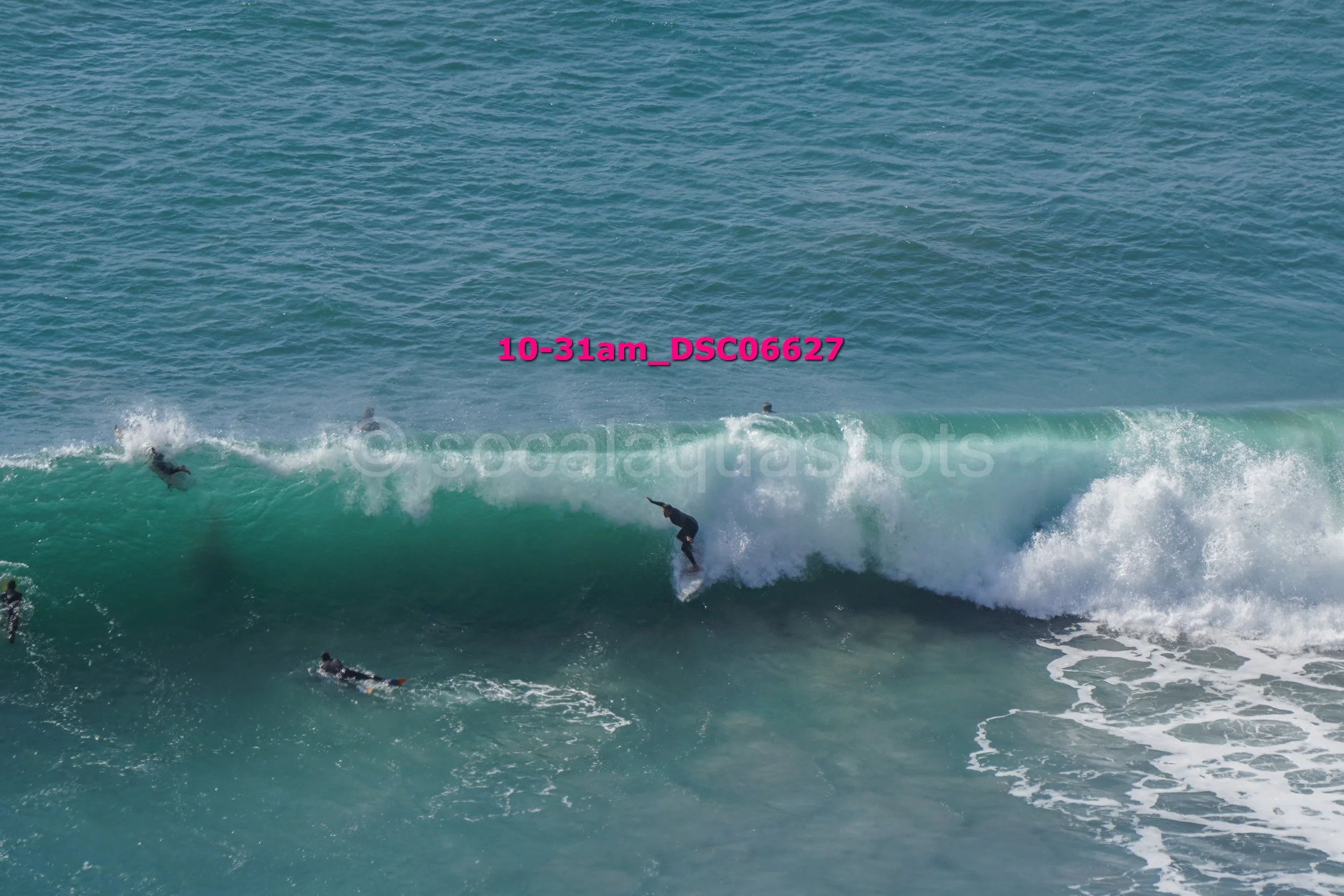 Surfers riding ocean waves with others waiting in the water.