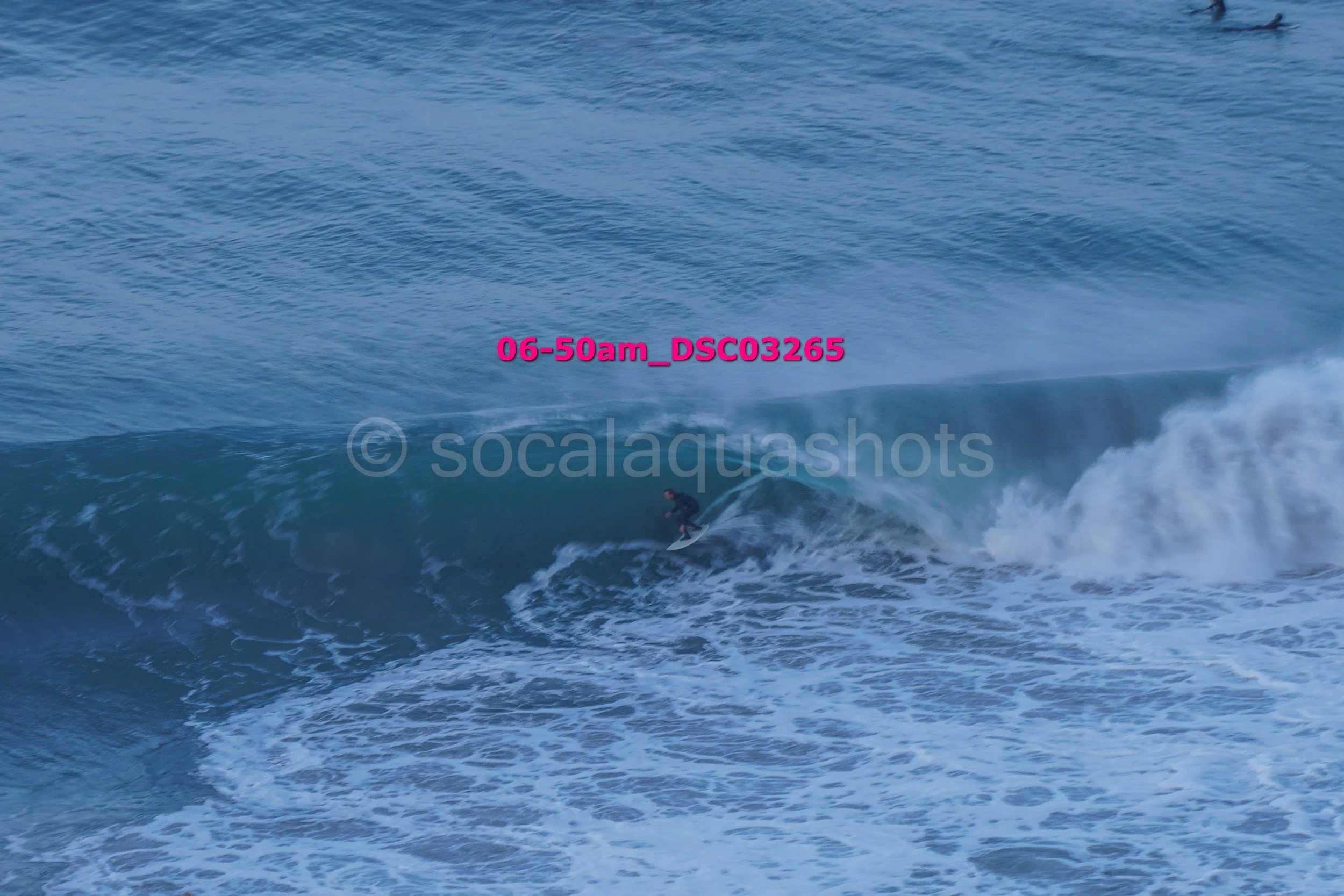 Surfer riding a large wave in the ocean.