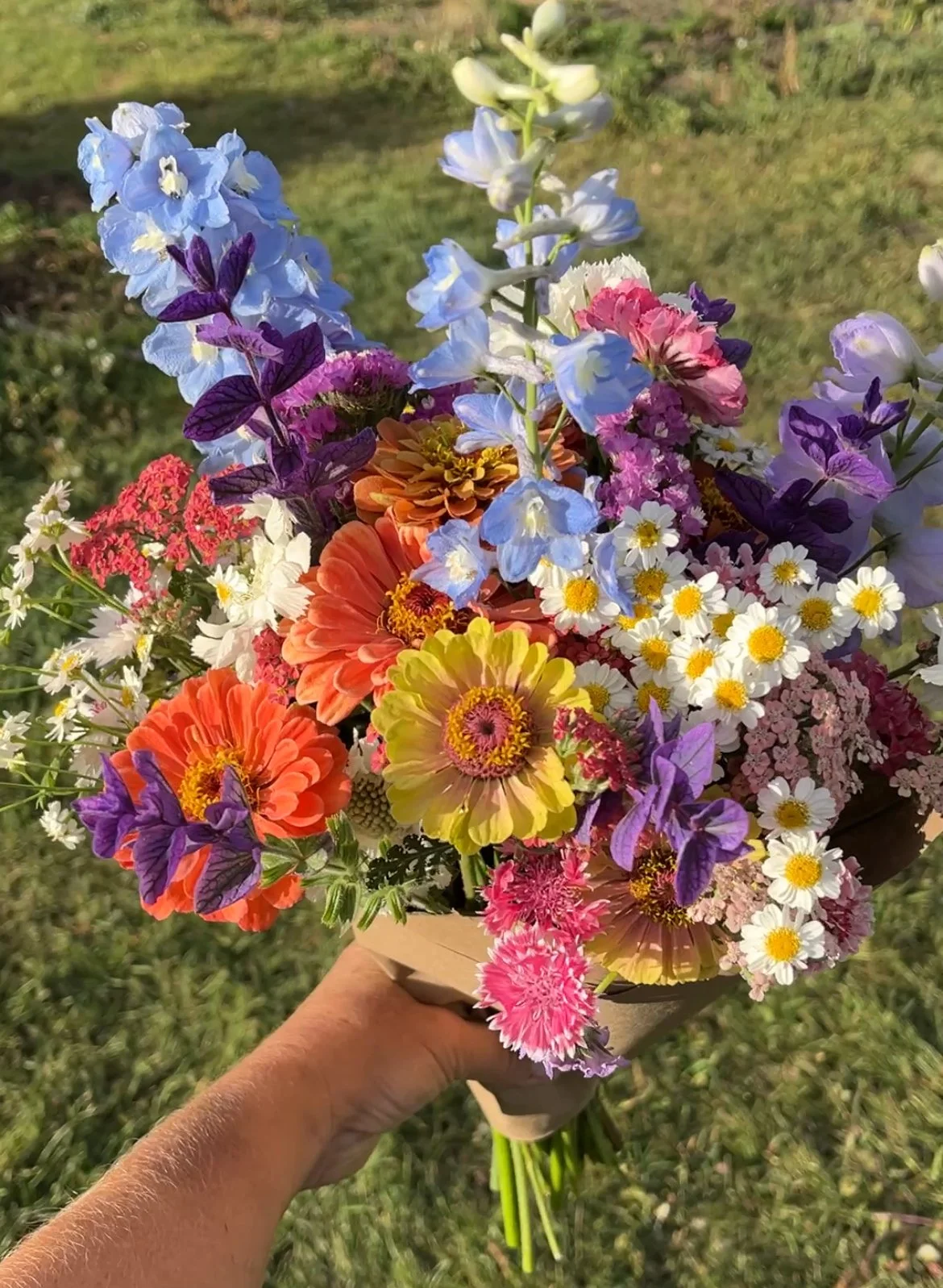 Flower bouquet with delphinium, zinnias, painted sage, feverfew, yarrow, bachelor buttons and statice
