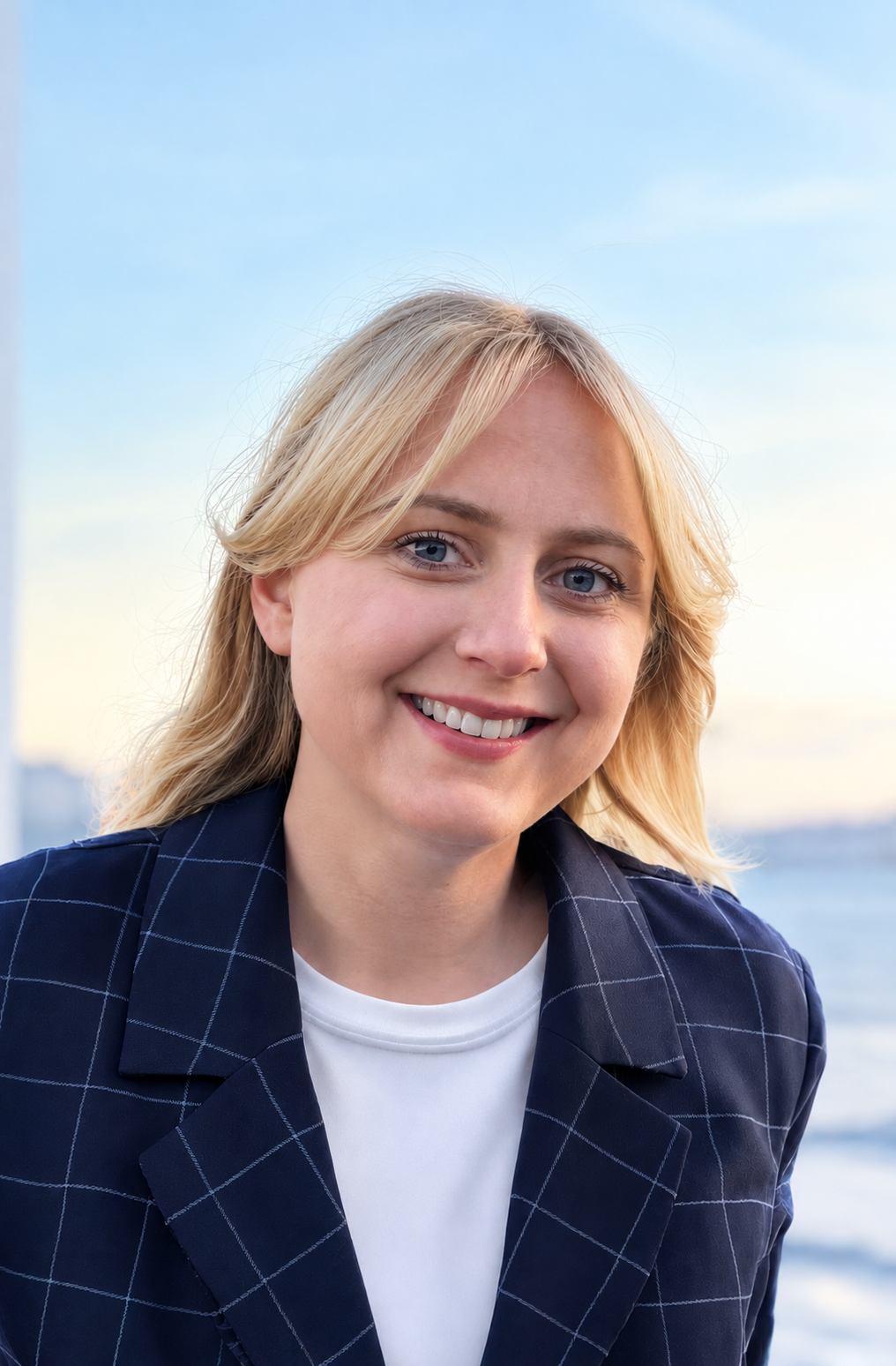 Woman with blonde hair smiling in a suit