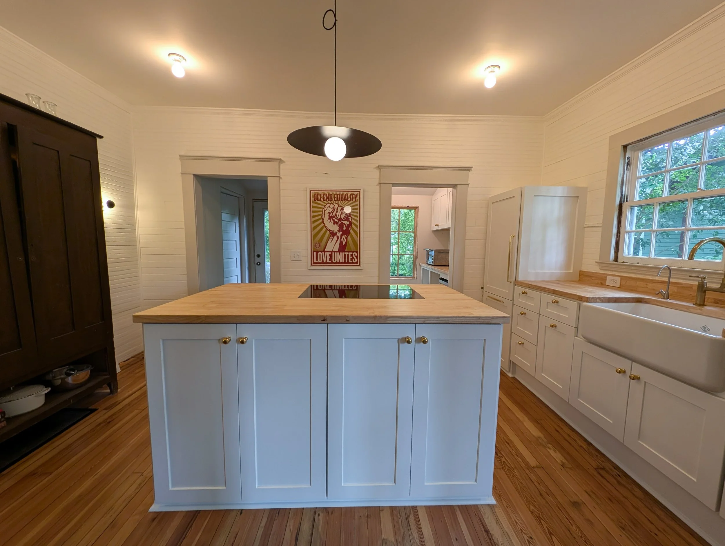 Straight view of island with white shaker cabinets and butcherblock counters