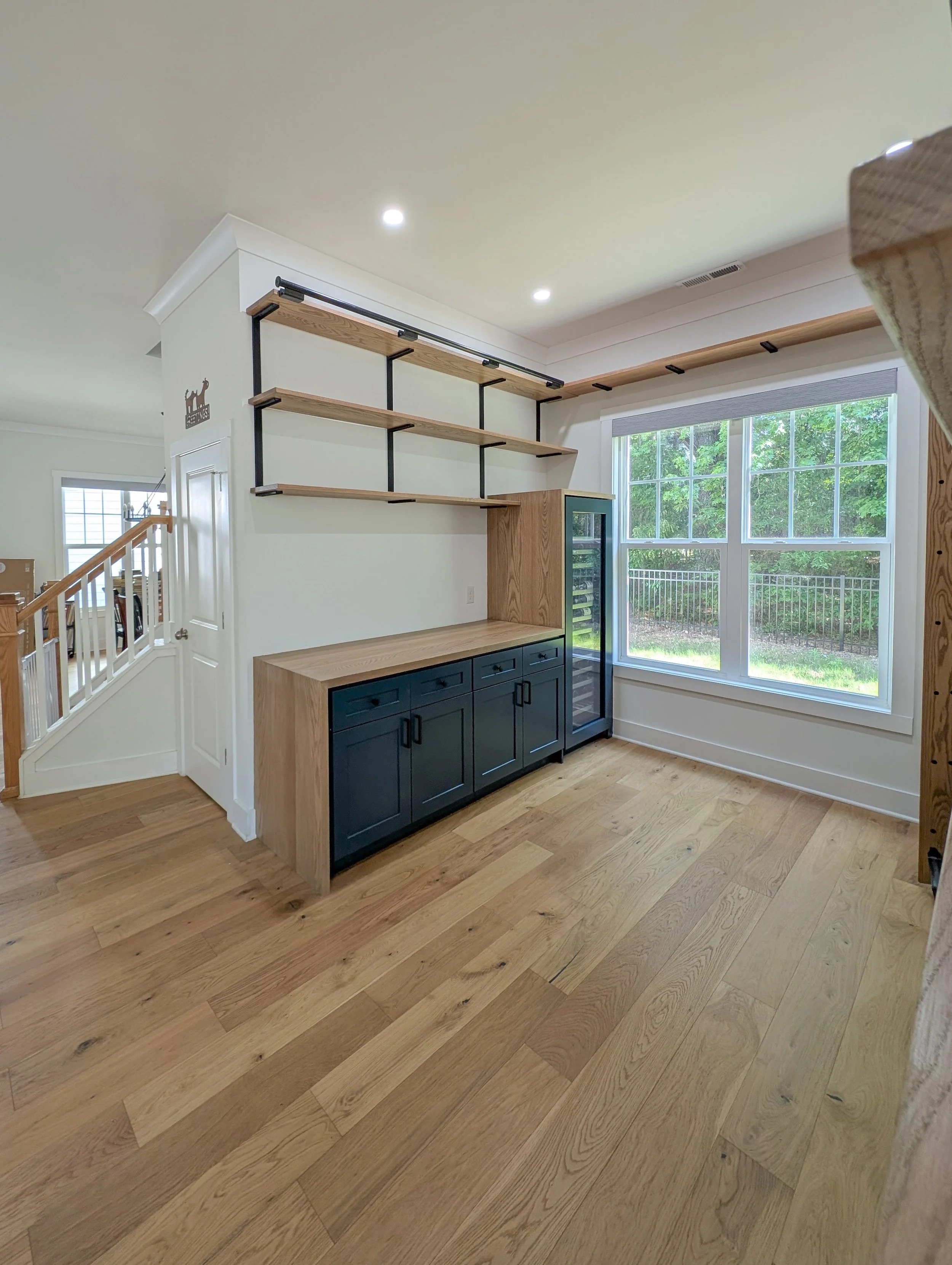 Library with dry bar. White oak shelving, countertops, cabinets and rolling ladder