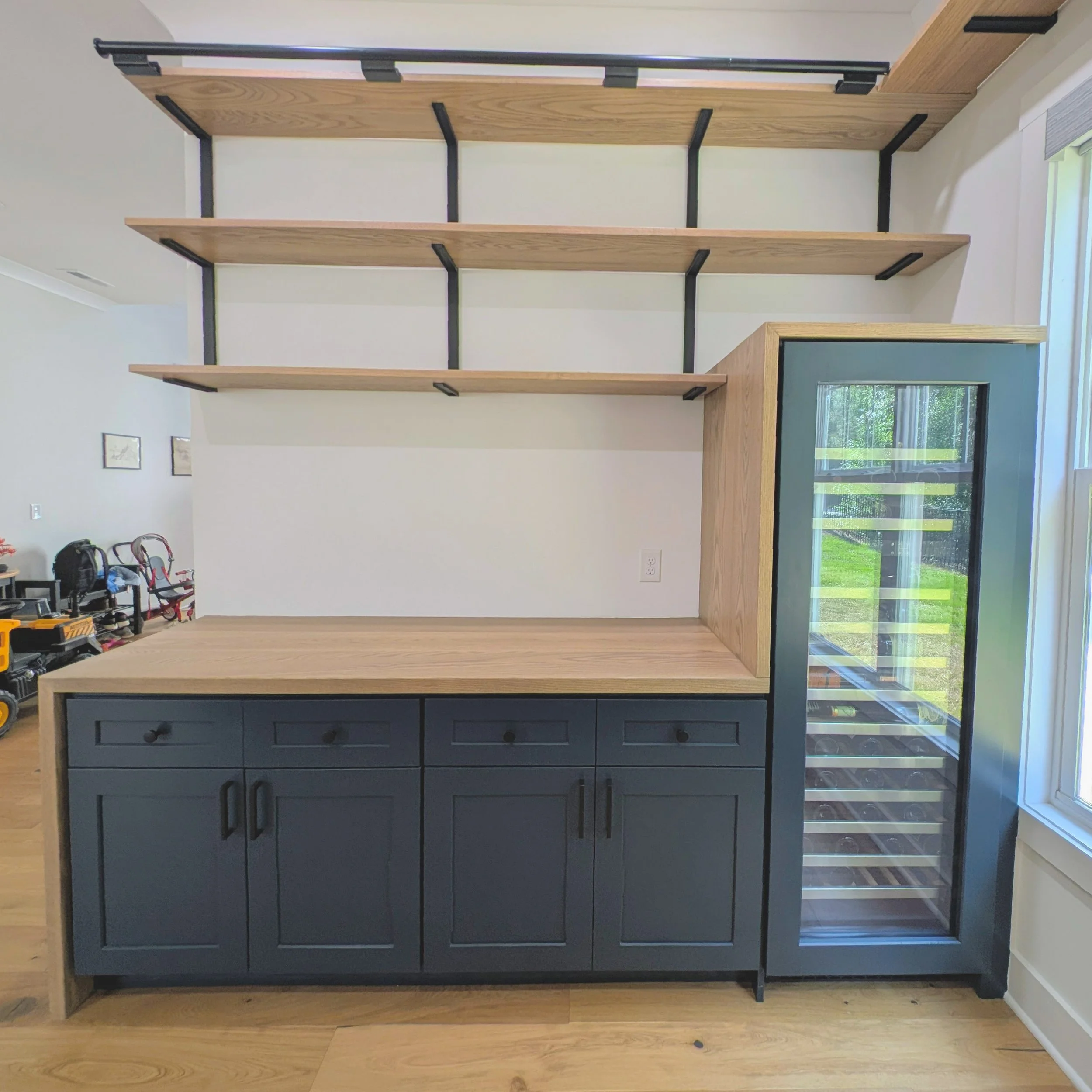 Library with dry bar. White oak shelving, countertops, cabinets and rolling ladder