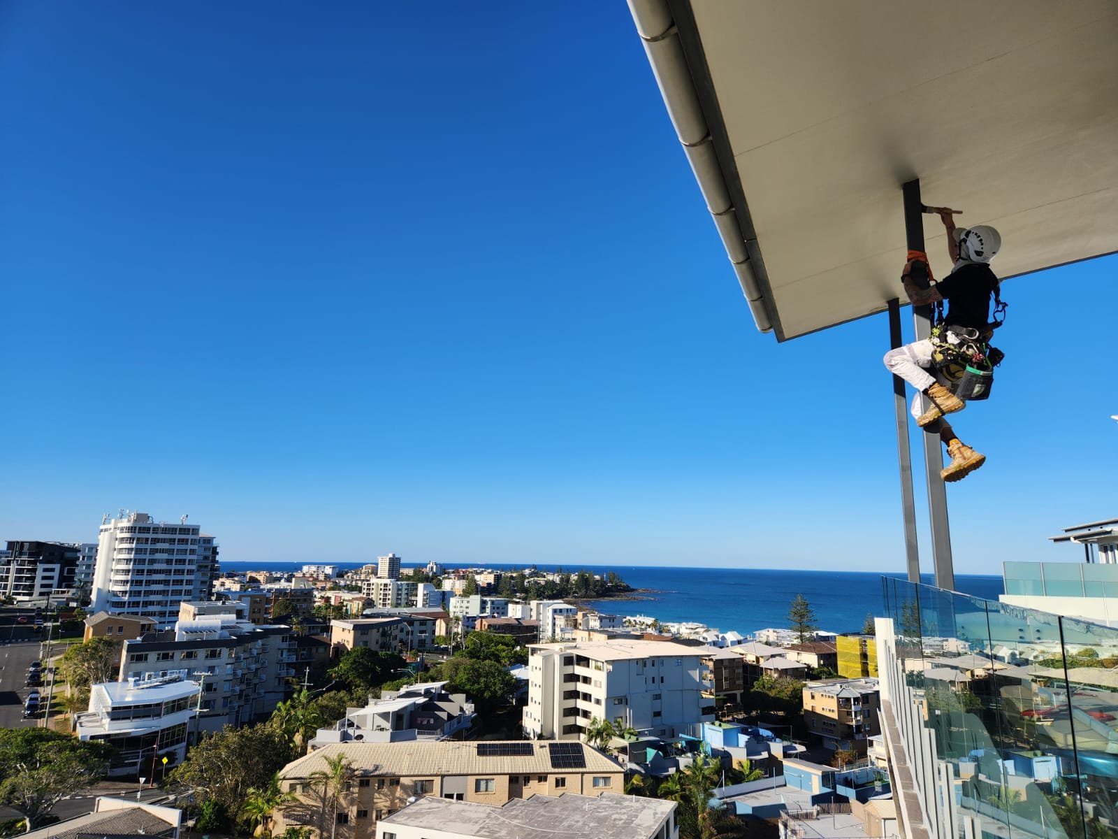 Rope access technician working on a Sunshine Coast residential property, ensuring precise application of premium paints and revitalising the home’s exterior with a fresh, modern finish.