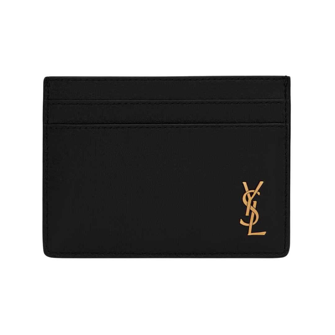 A black leather card holder featuring a gold Saint Laurent YSL metal monogram on the front.