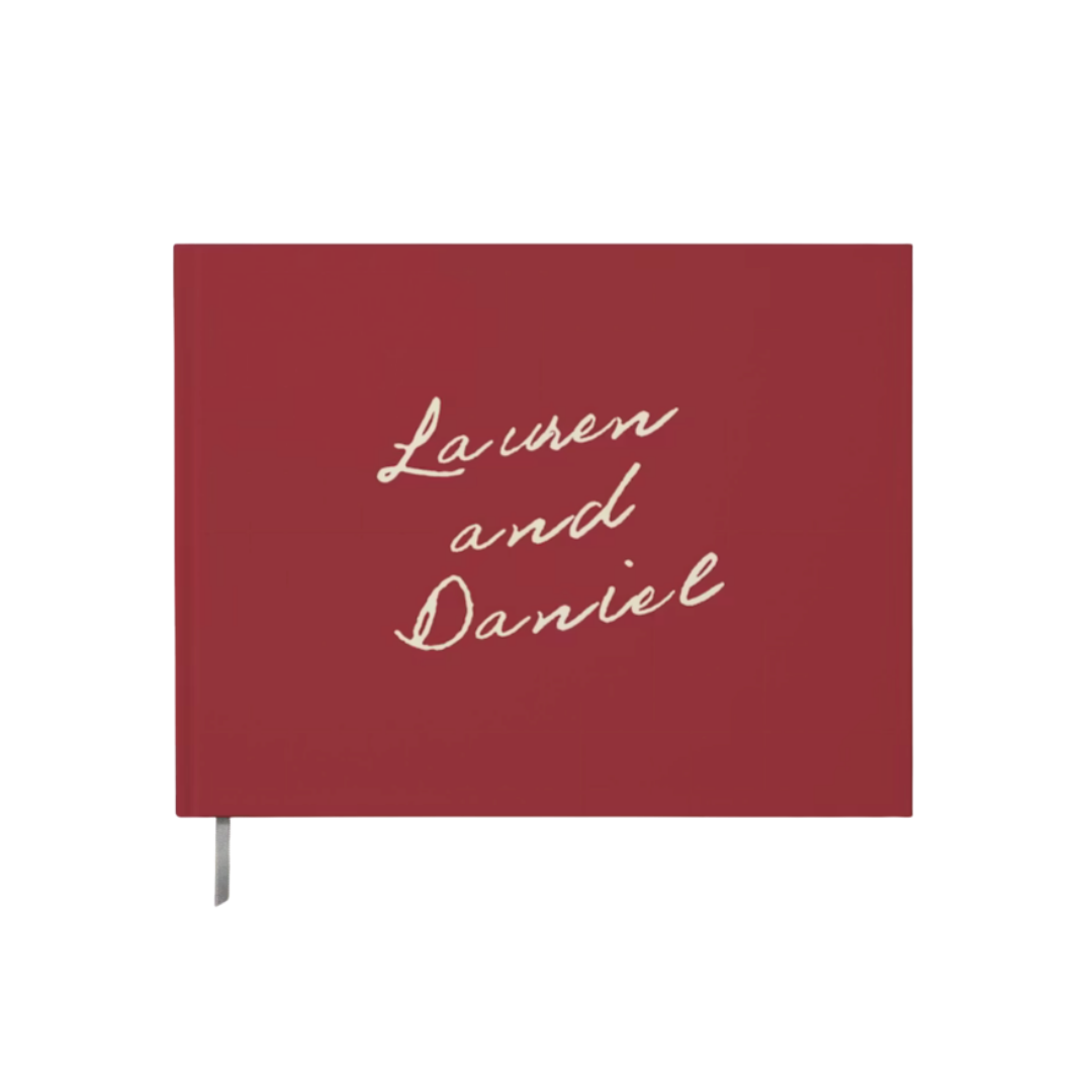 A deep red hardcover guest book personalized with the names "Lauren and Daniel" in elegant white cursive script.