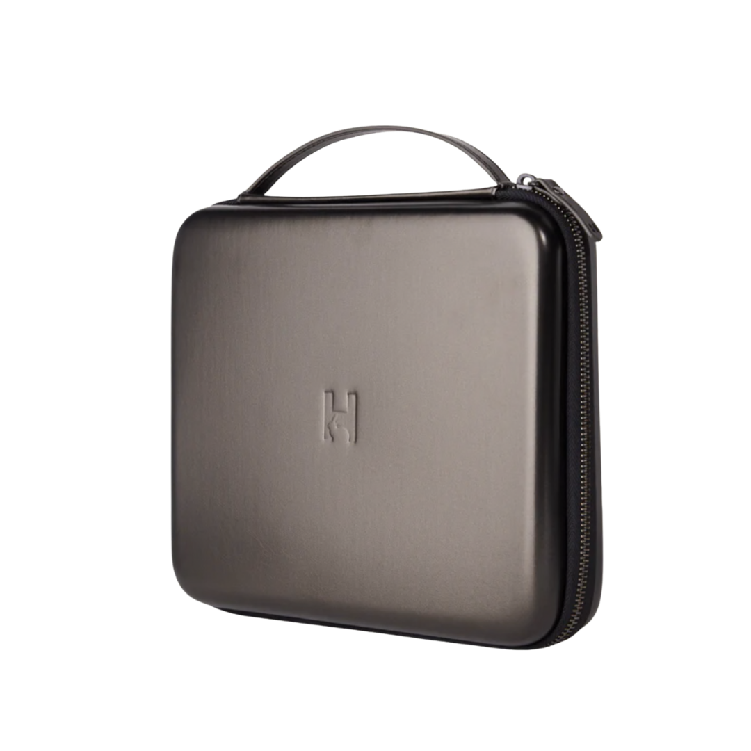 A structured, dark metallic grey vegan leather brush canister with a minimalist 'H' logo.