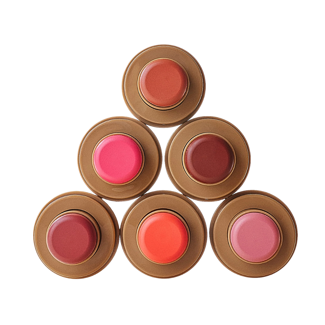 A pyramid stack of six circular Rhodes pocket blush compacts in various shades of pink, peach, and berry.