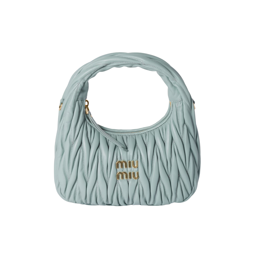 A small, curved Miu Miu Wander hobo bag in a dusty blue quilted matelassé leather.