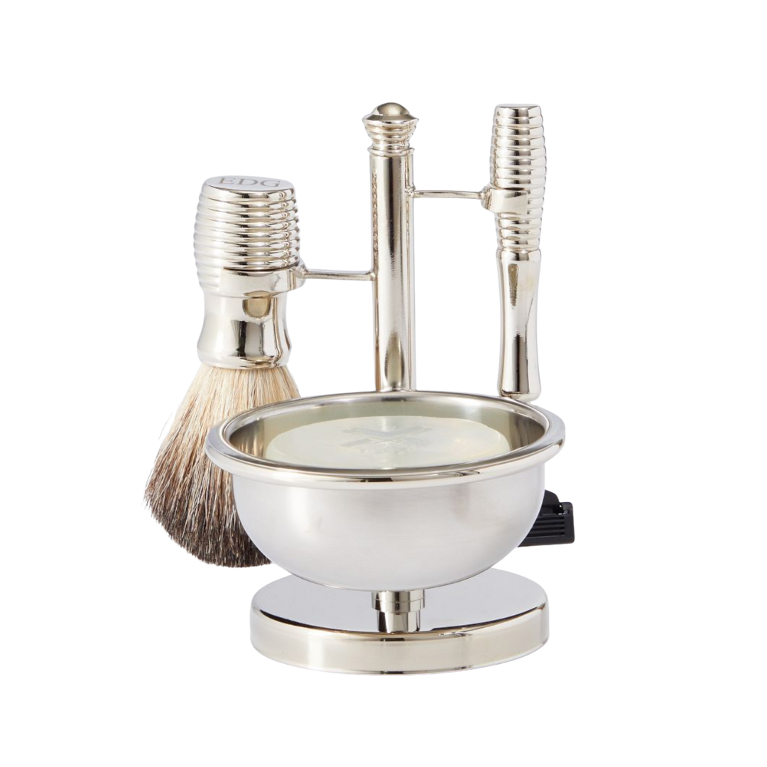 A four-piece polished silver shaving set including a badger-hair brush, a safety razor, and a metal soap bowl on a stand.
