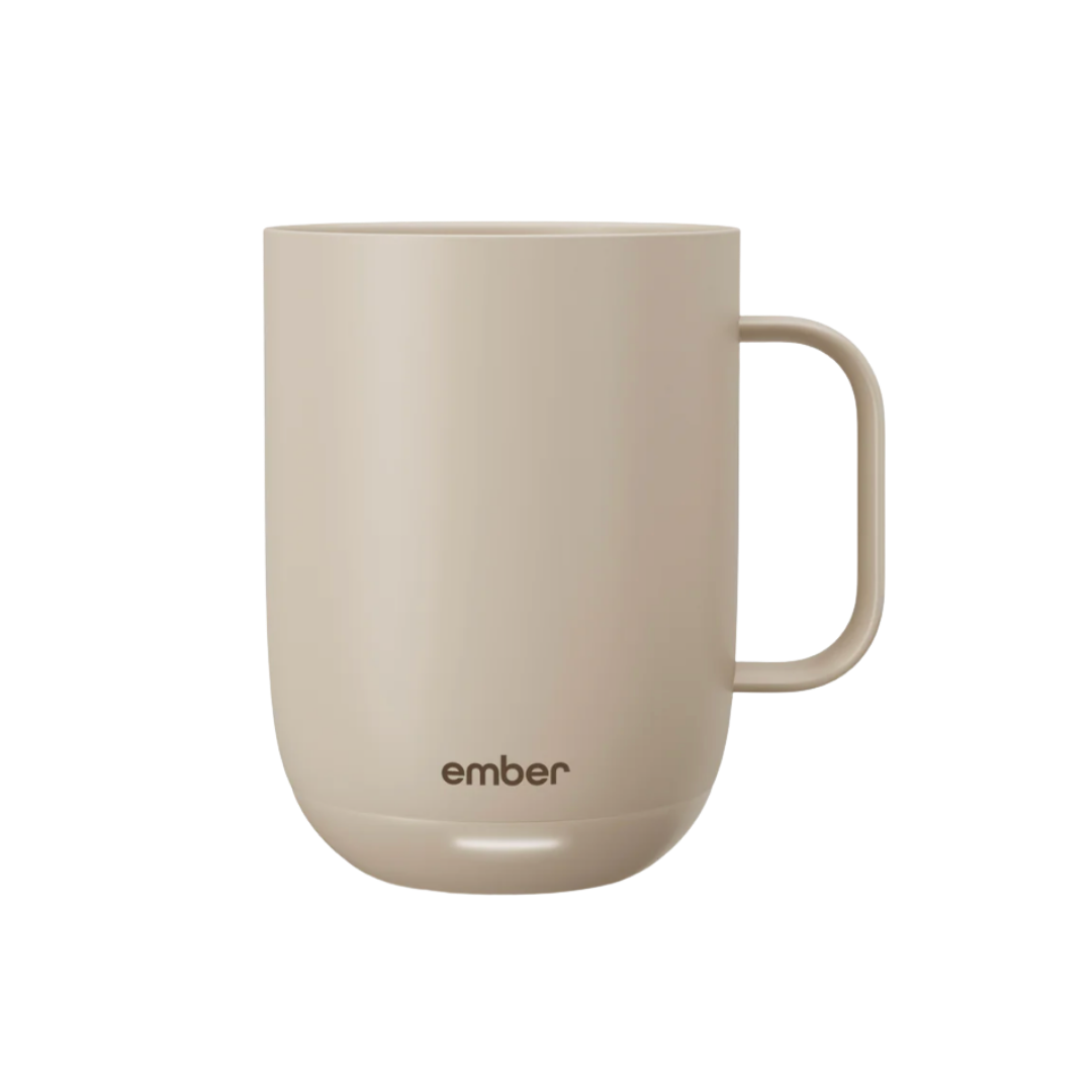 A matte sand-colored temperature-controlled smart mug with a small 'ember' logo and a glowing light at the base.