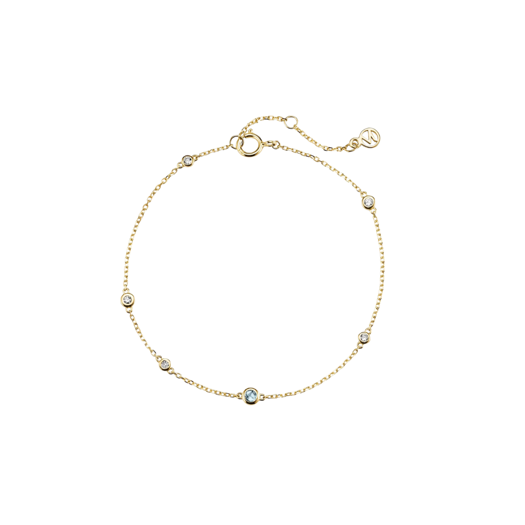 A thin gold chain bracelet featuring small, circular gemstone stations in various soft colors.