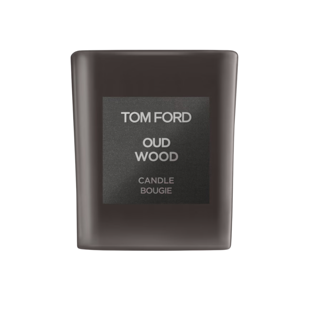 A dark smoke-grey glass Tom Ford candle jar with a structured square face and a minimalist 'Oud Wood' label.
