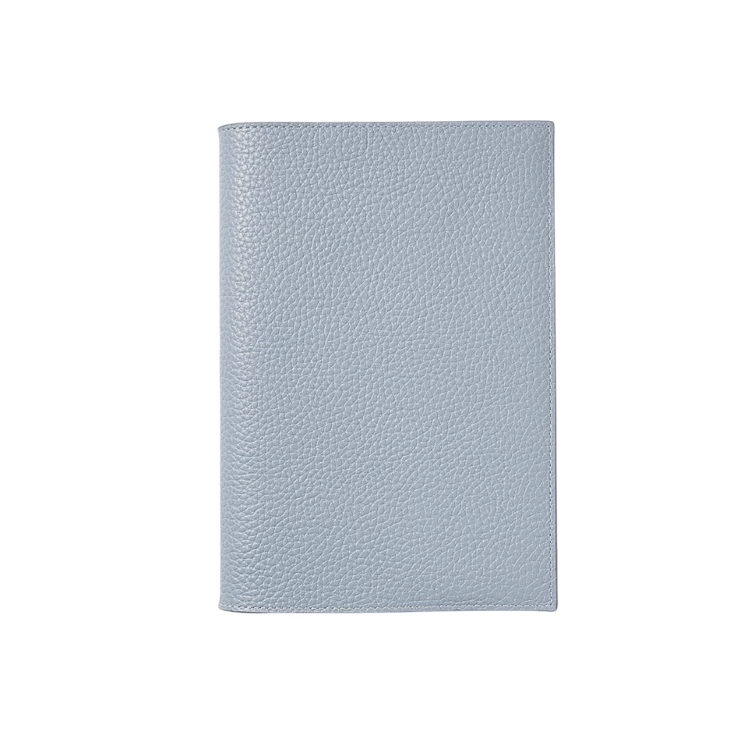 A vertical sky blue pebbled leather journal with a minimalist, high-end finish.