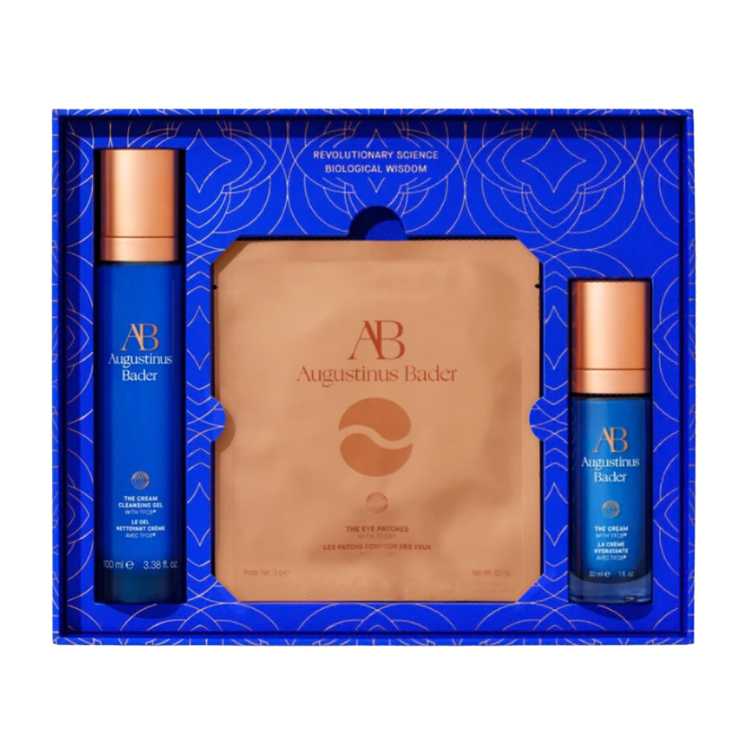 An Augustinus Bader gift set in a vibrant blue and gold box, featuring 'The Rich Cream' and matching copper-toned eye patches.
