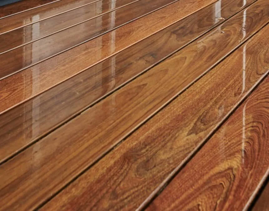 Close-up of polished wooden flooring with distinct grain patterns and reflections.