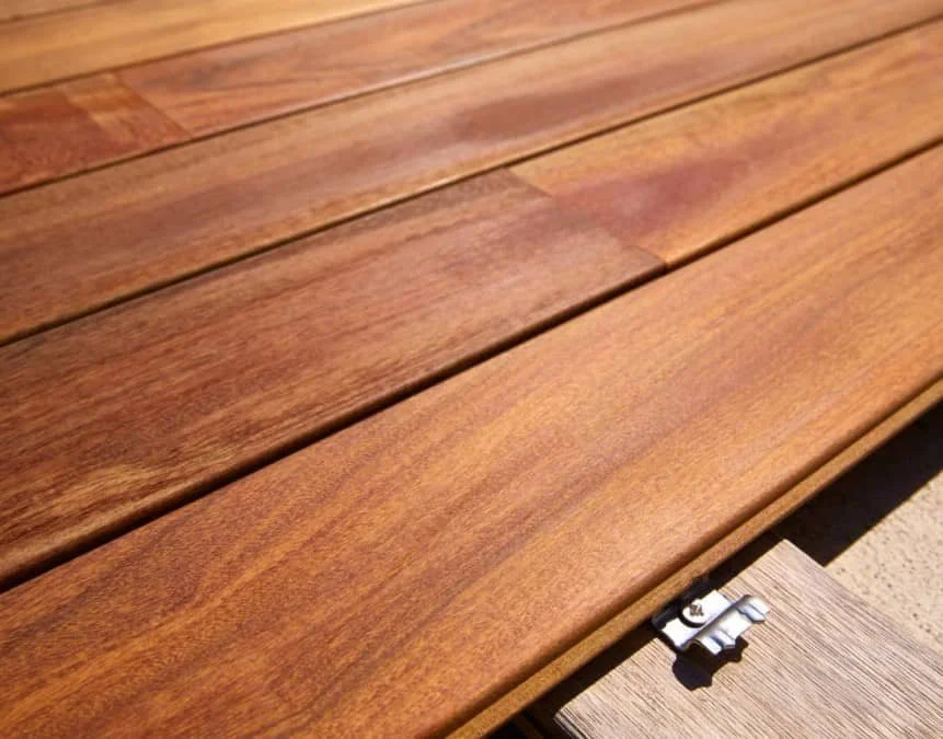 Close-up of wooden deck boards with a fastener clip.