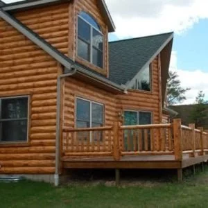 Log cabin with wooden deck and large windows
