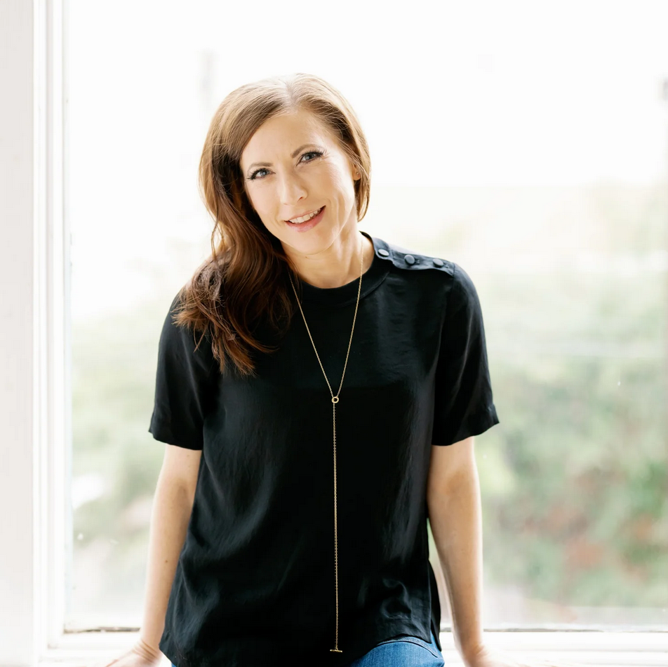 Woman in a black top, Sitting on Window smiling