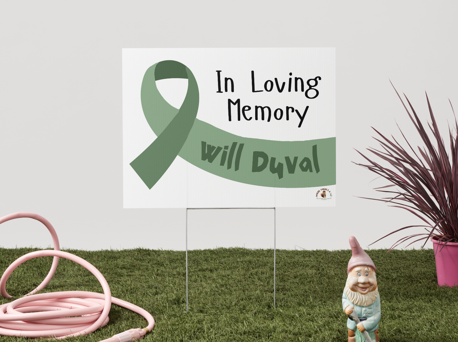 yard sign with large green ribbon reading in loving memory with personalized name