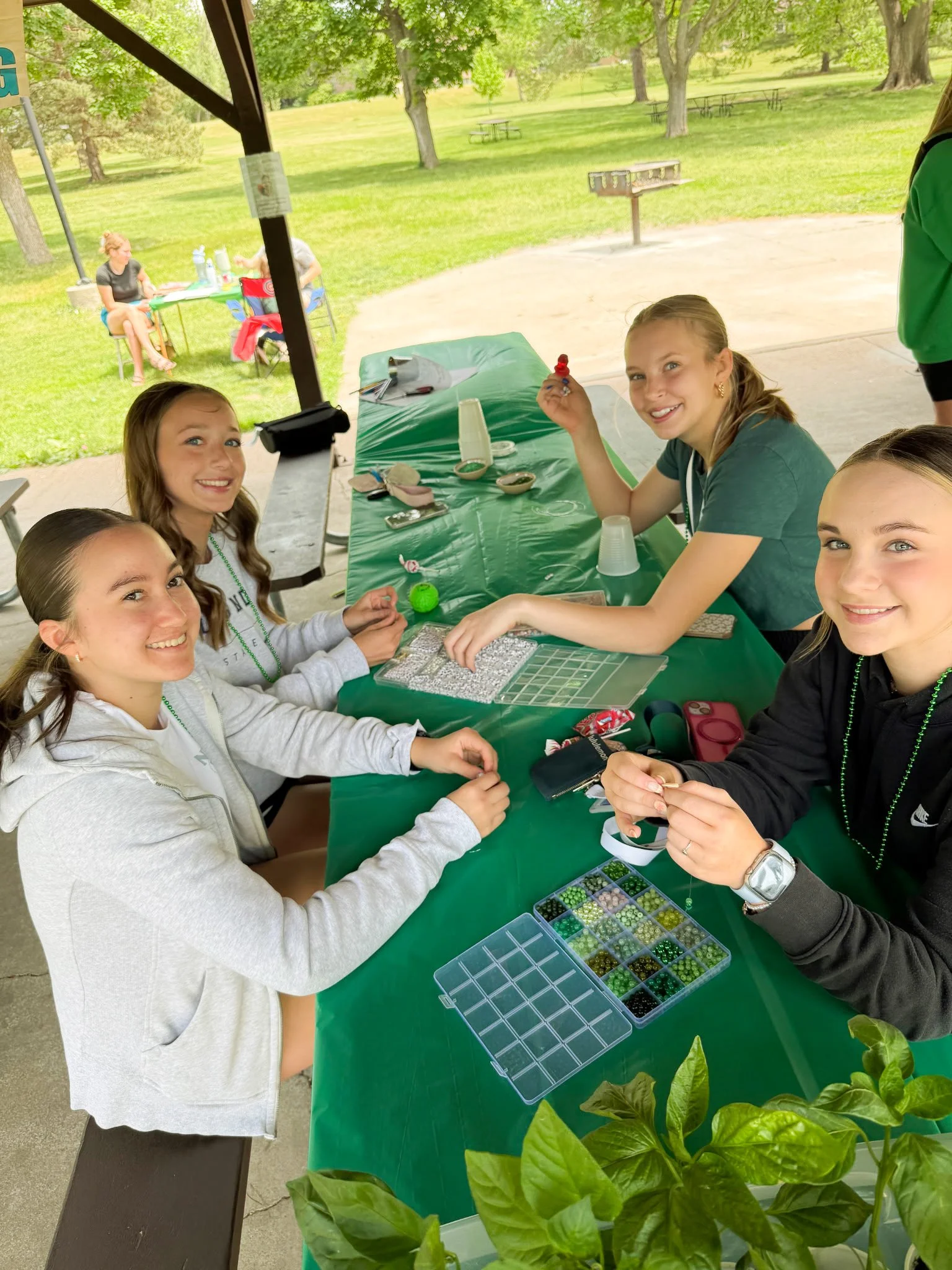 4 teen girls make beaded friendship bracelets