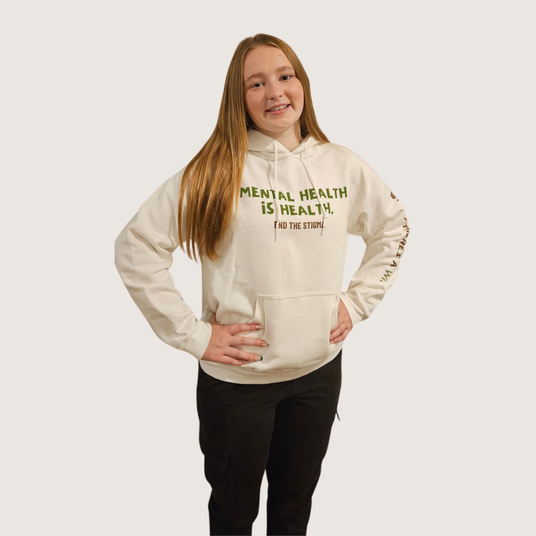 a female model wearing a white sweatshirt that reads mental health is health. end the stigma