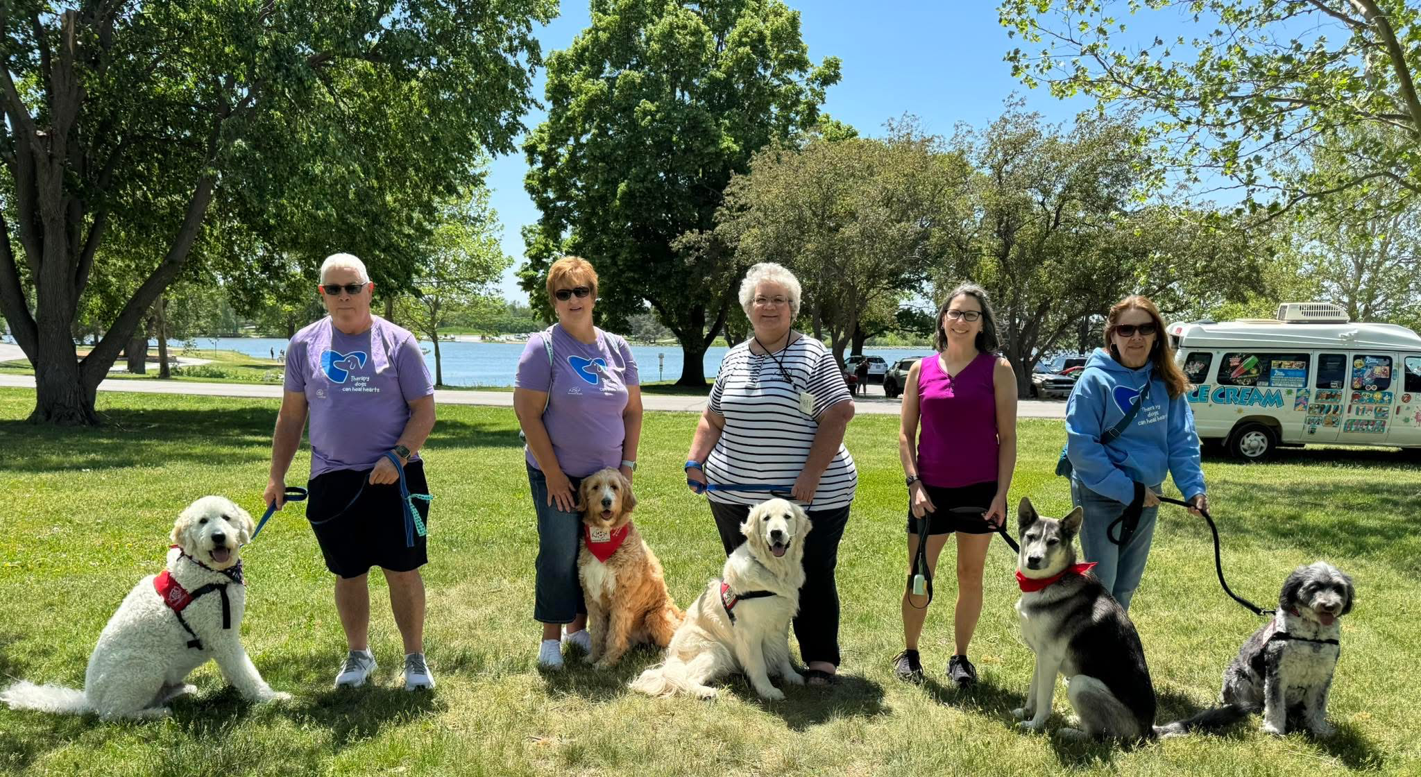 5 domesti-pups volunteers pose with their therapy dogs
