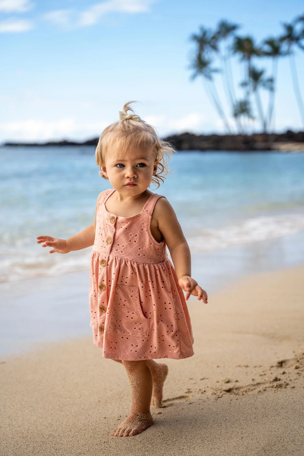 little girl walking on a white sandy beach on the big island of hawaii