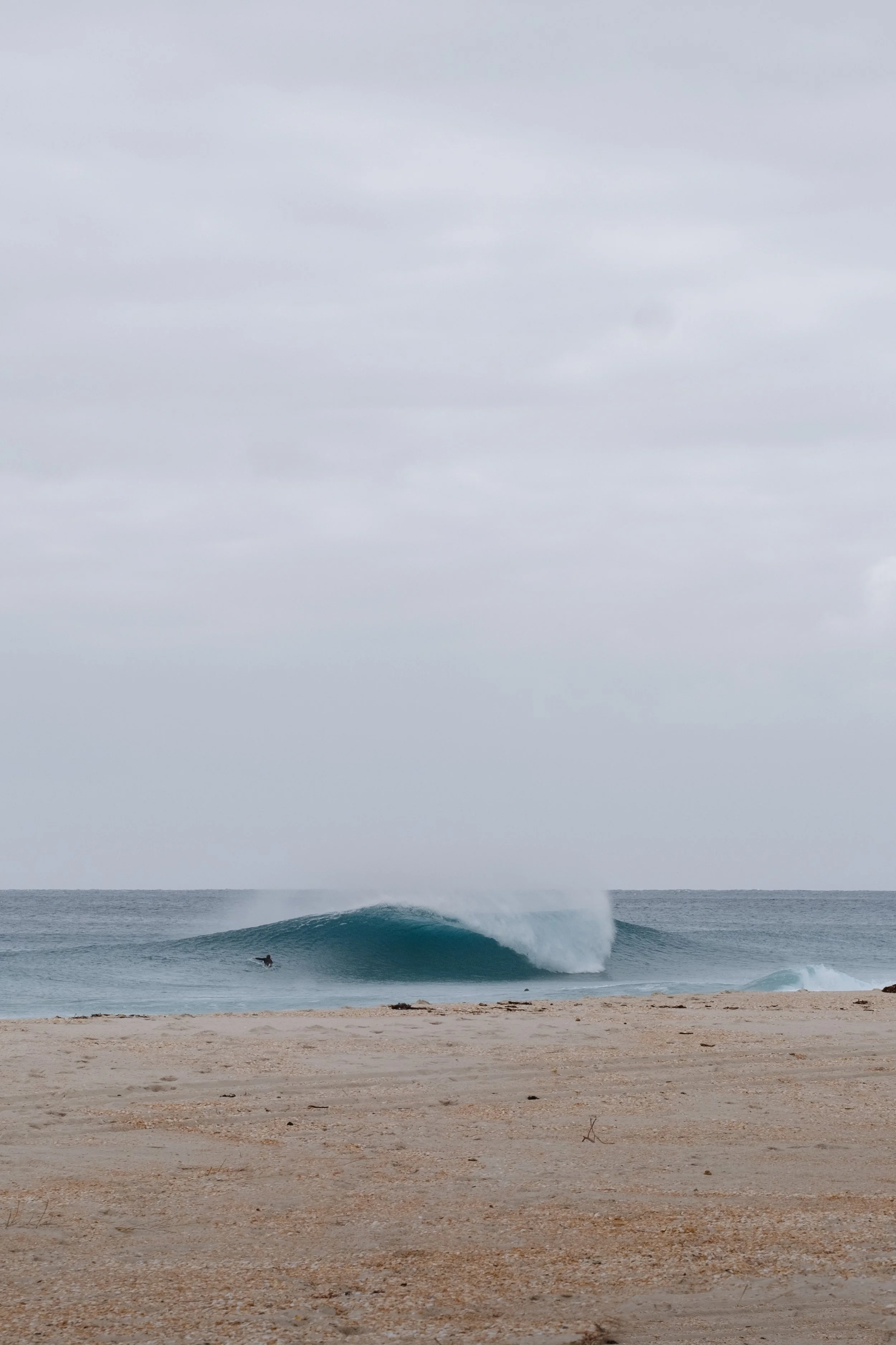 Overcast day at the beach with ocean waves and surfing