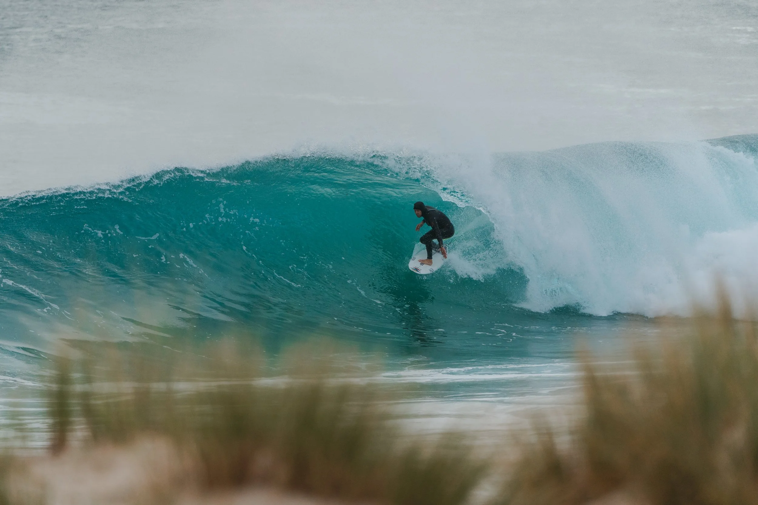 A person surfing on a wave in the ocean, seen from the shore.