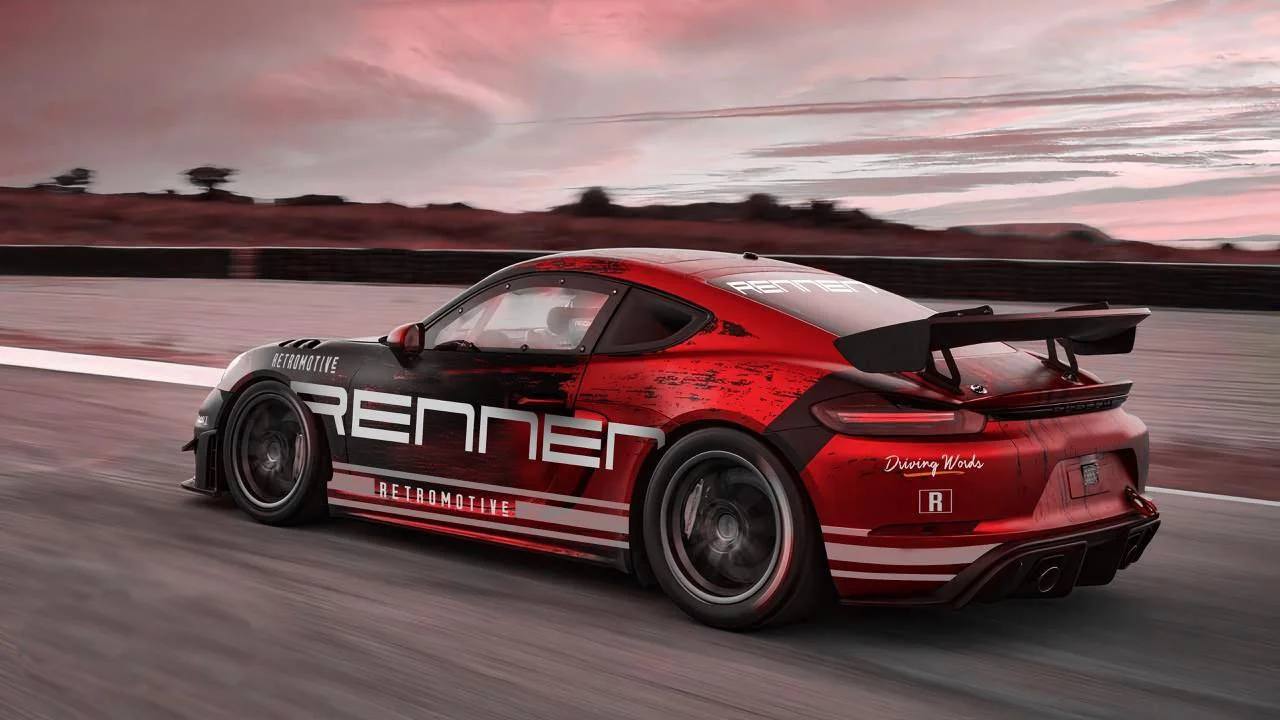 Red and black Porsche race car with aerodynamic spoiler driving on a race track at sunset.