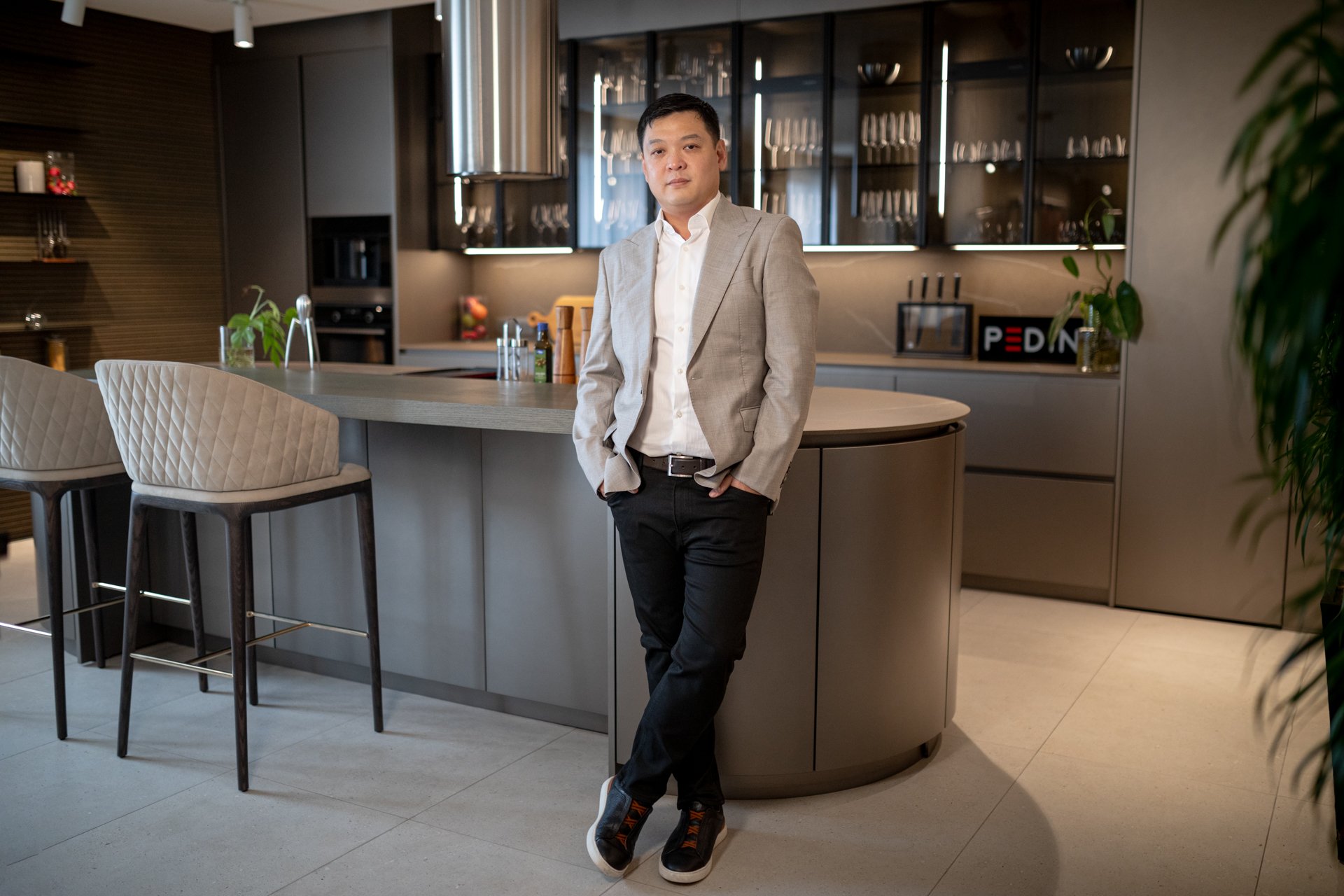 Goldwin Sison, President of Moda Interni, standing beside a Pedini kitchen