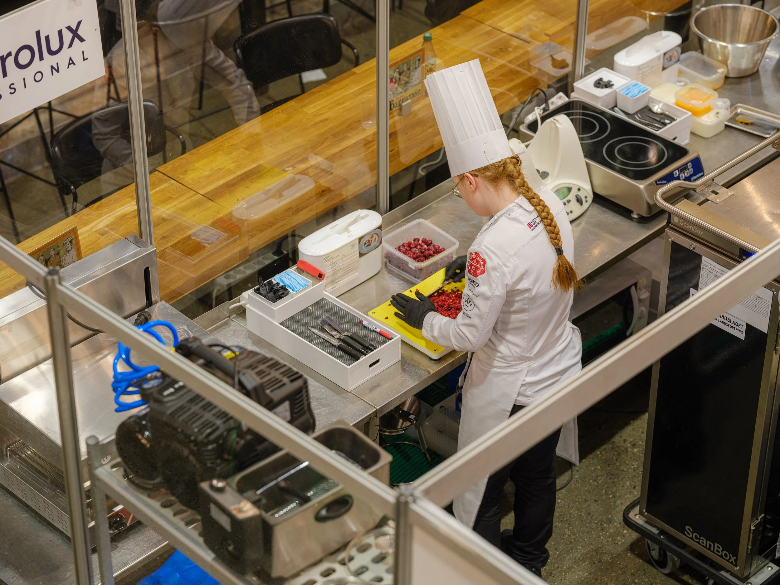 Kokke jobber med å kutte røde bær i et kjøkken.