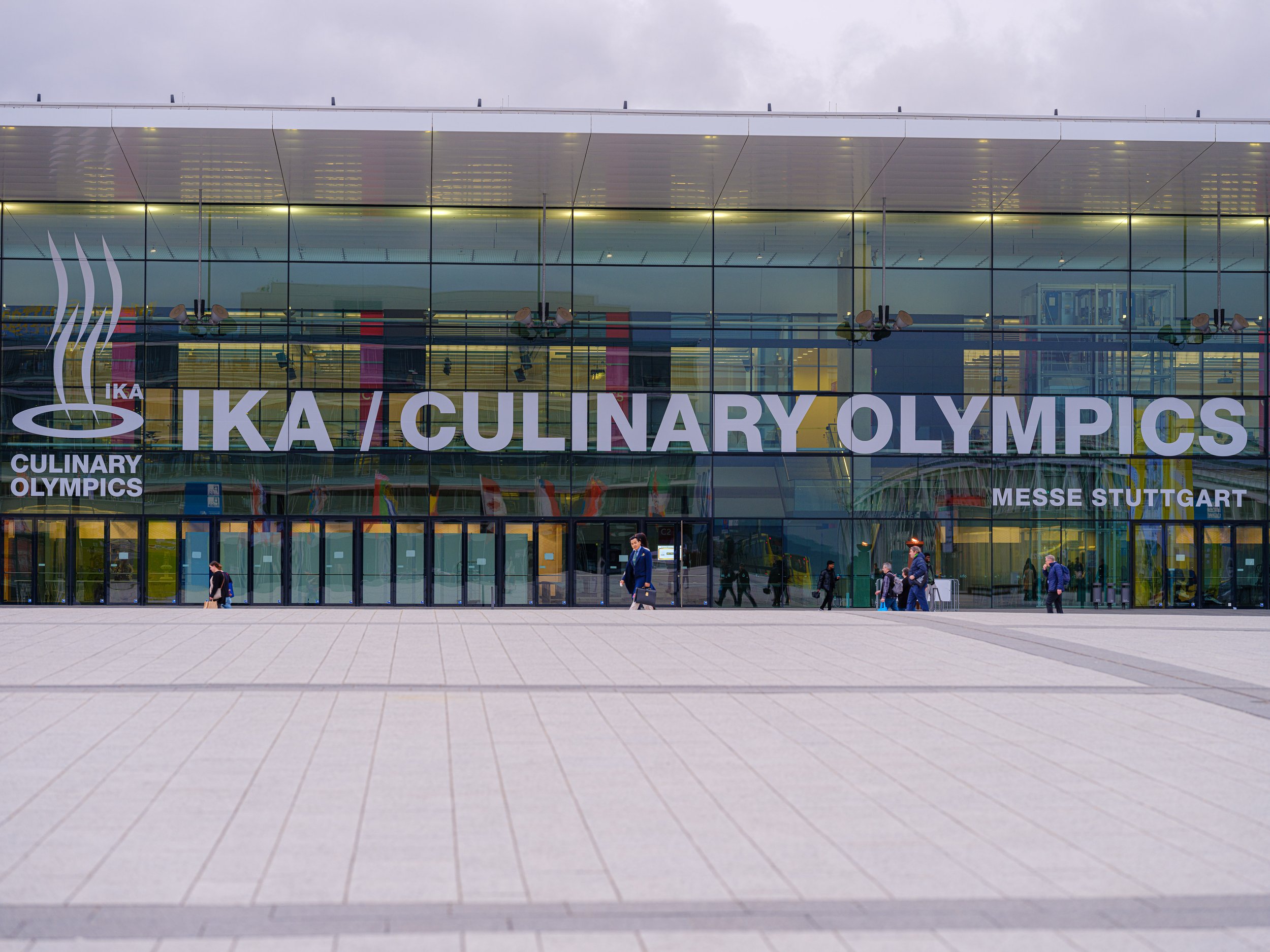Bildet viser inngangsdøren til Messe Stuttgart med store vinduer og logoen for IKA Ldefined/Culinary Olympics.