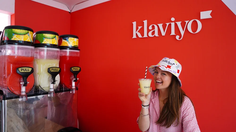 Guest holding a Klaviyo slushie beside the frozen-drink machine at Cannes Lions 2024