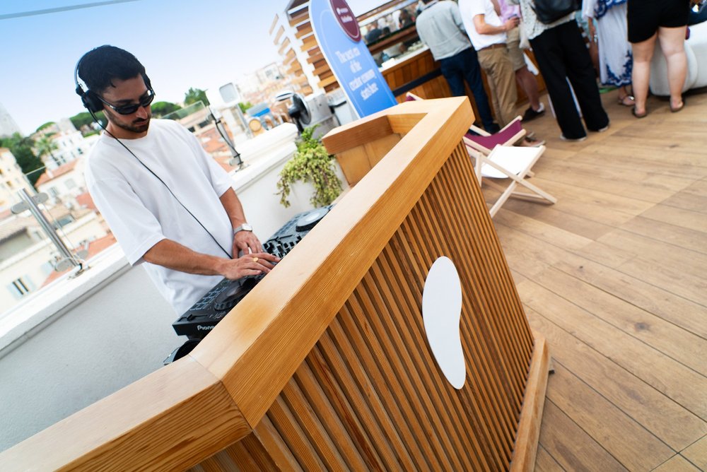 DJ at the wooden Creator Brand Space booth with custom Patreon branding at Cannes Lions