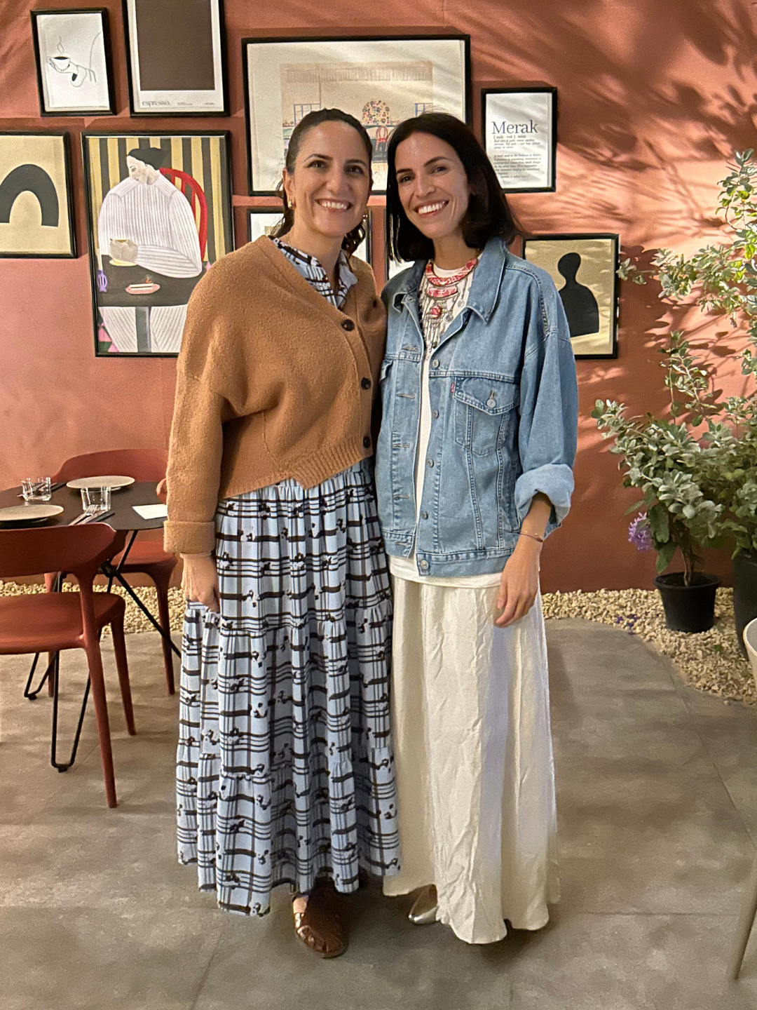The two founders of The Nadi, Shaden Abdellatif and Joanne Kubba, standing close together in a restaurant, smiling at the camera.