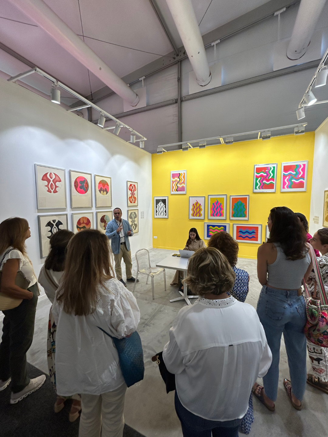 The Nadi event at an art gallery with colorful abstract paintings on white and yellow walls.