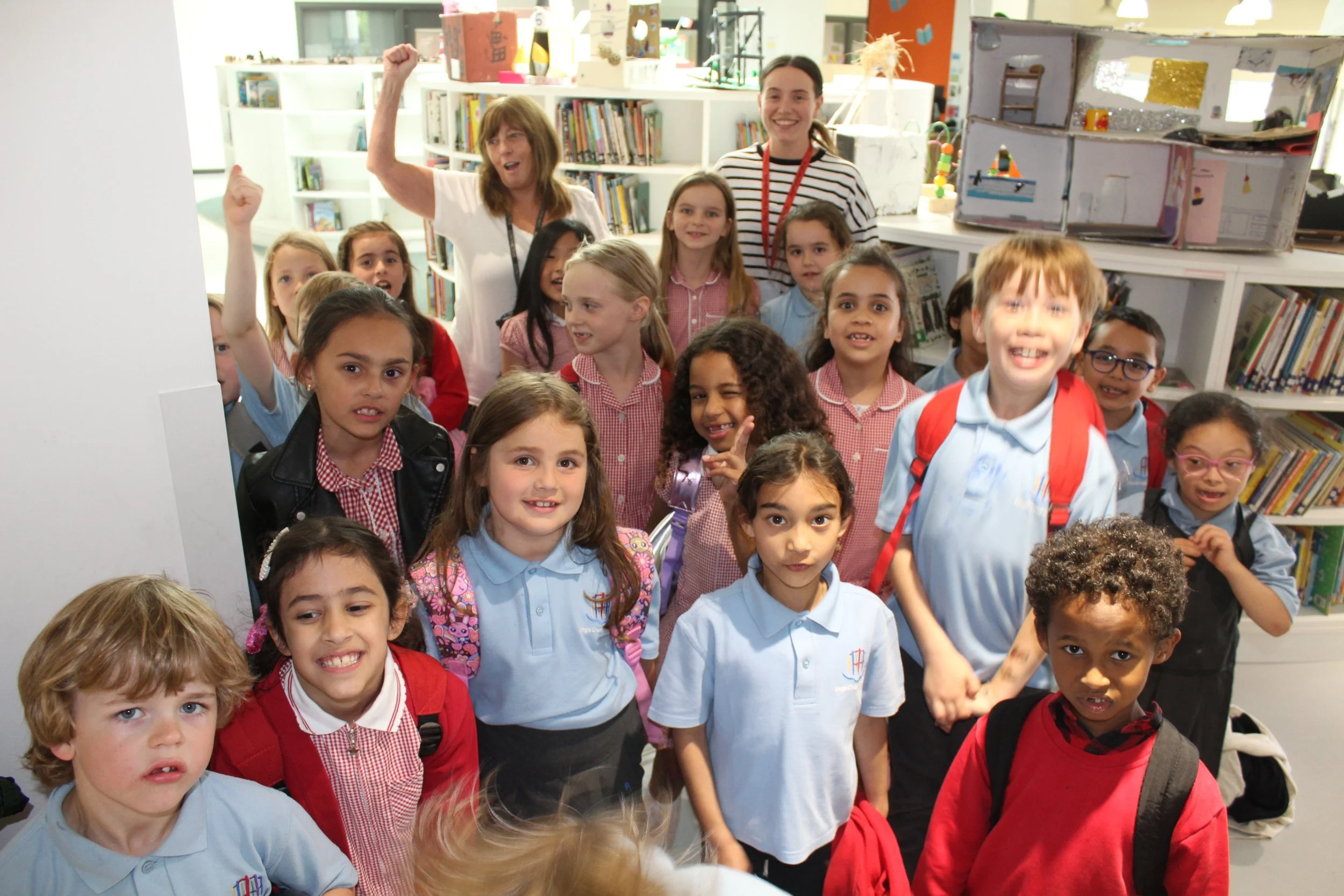 A large group of young school children smiling at the camera.