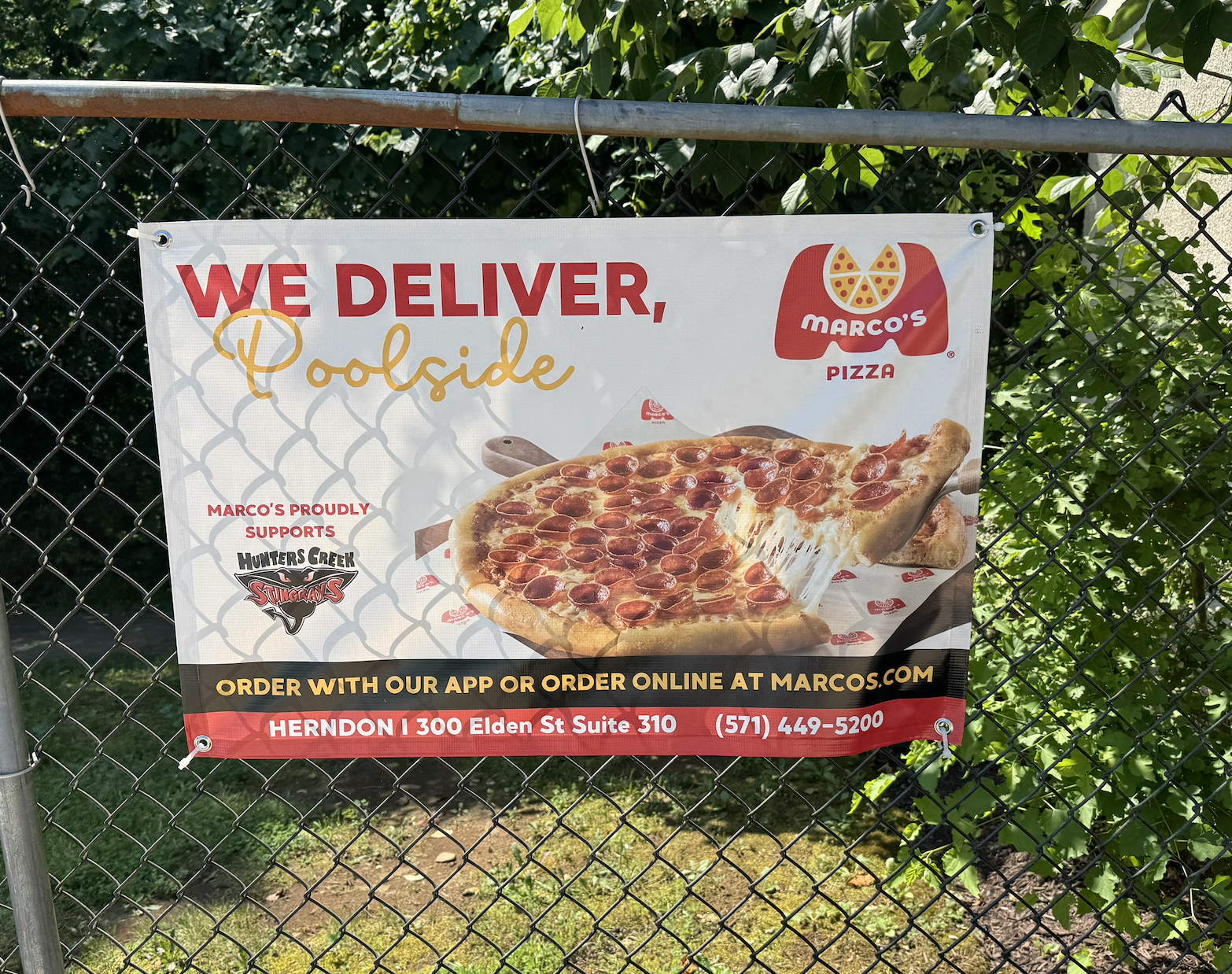 A modern house on a grassy hillside with snow-capped mountains in the background under a cloudy sky.