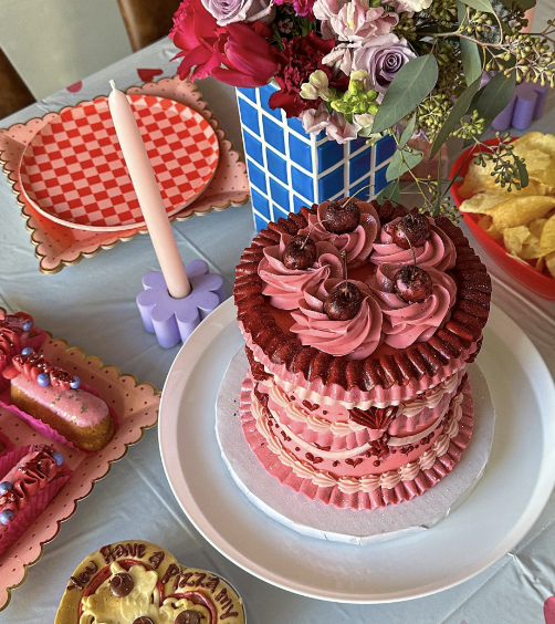 Deep pink cake with lots of frosting and cherries