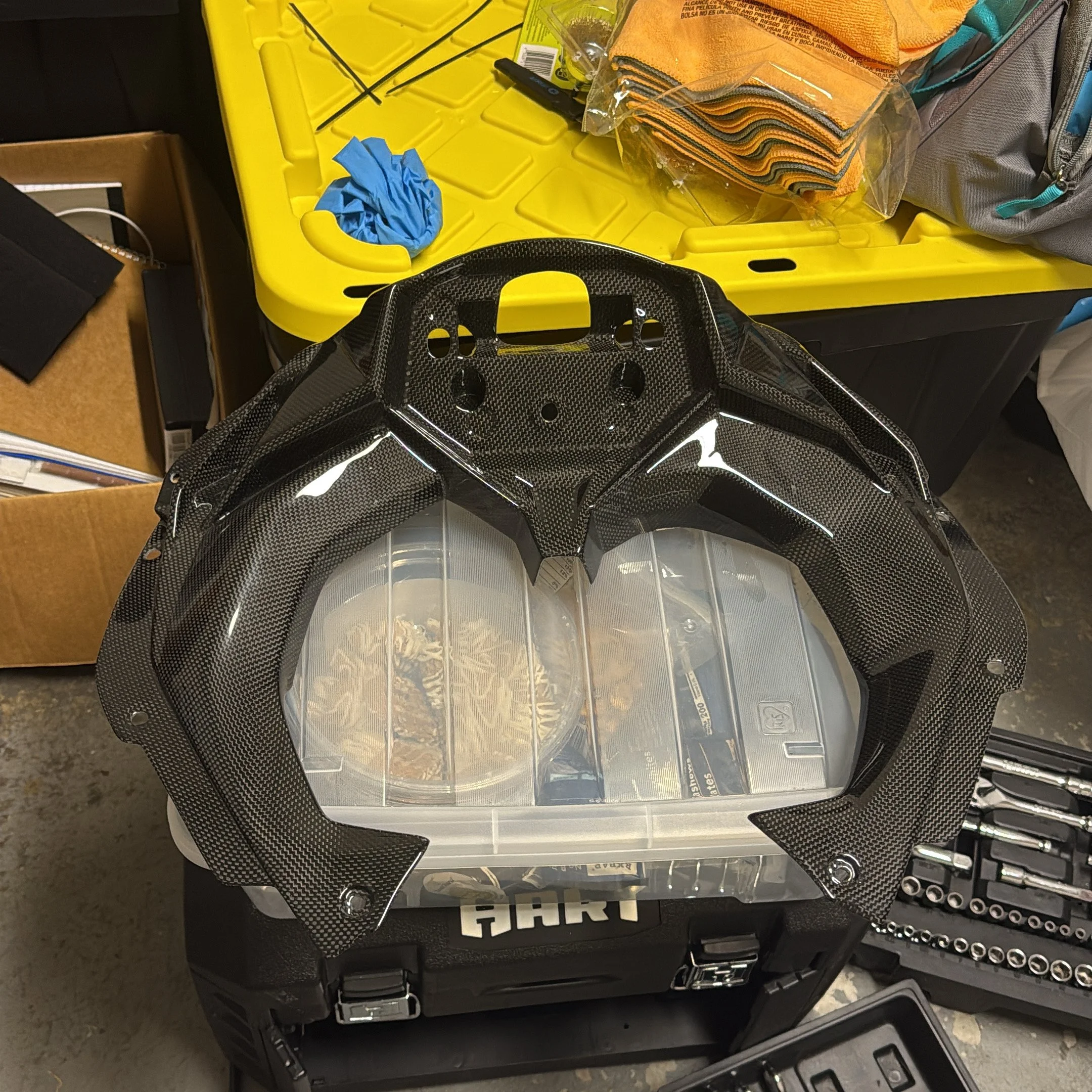 Carbon-fiber dashboard surround on a workshop bench beside tools