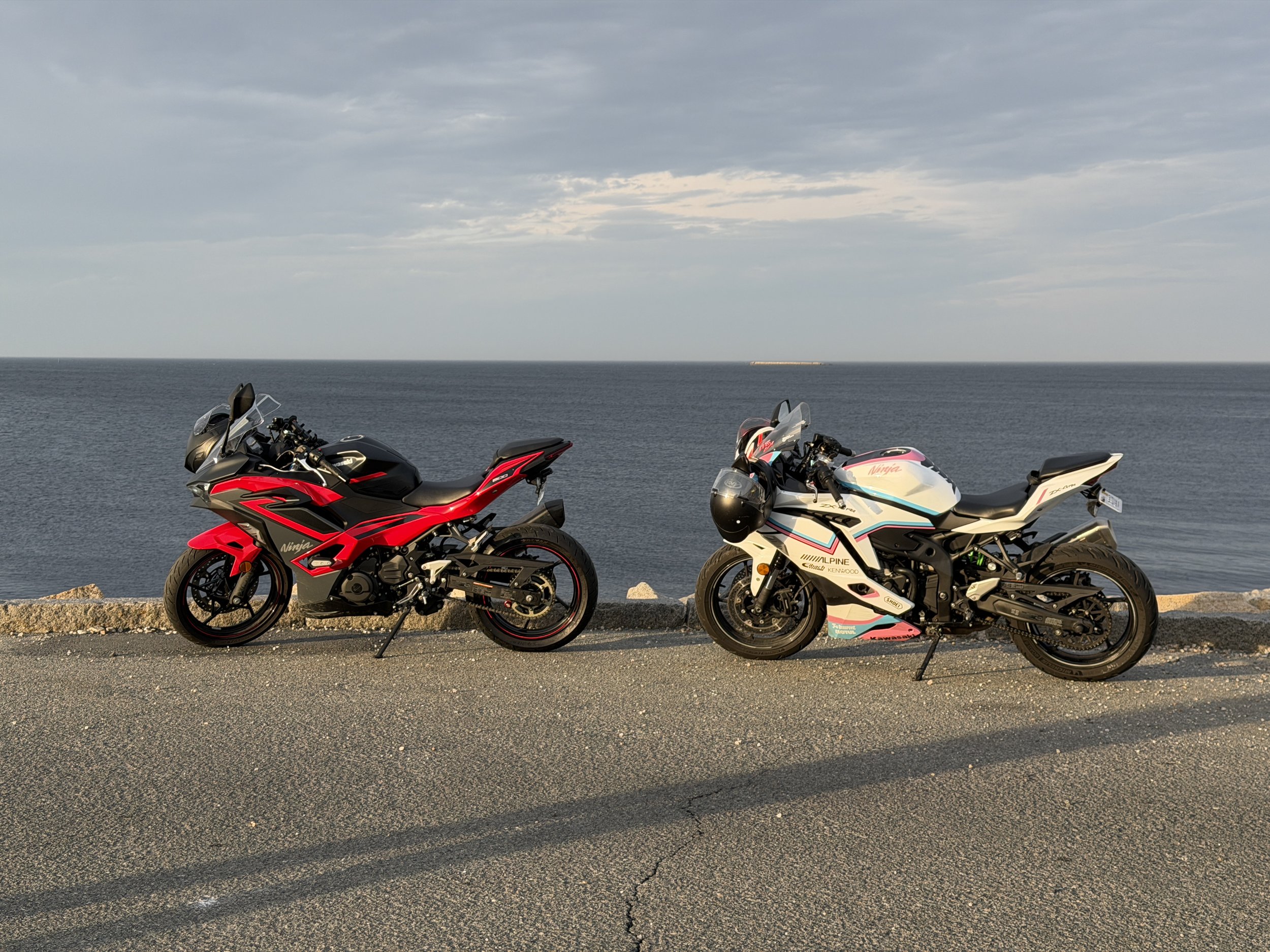 Kyle's white Kawasaki ZX4 with pink and teal fairings beside the coast